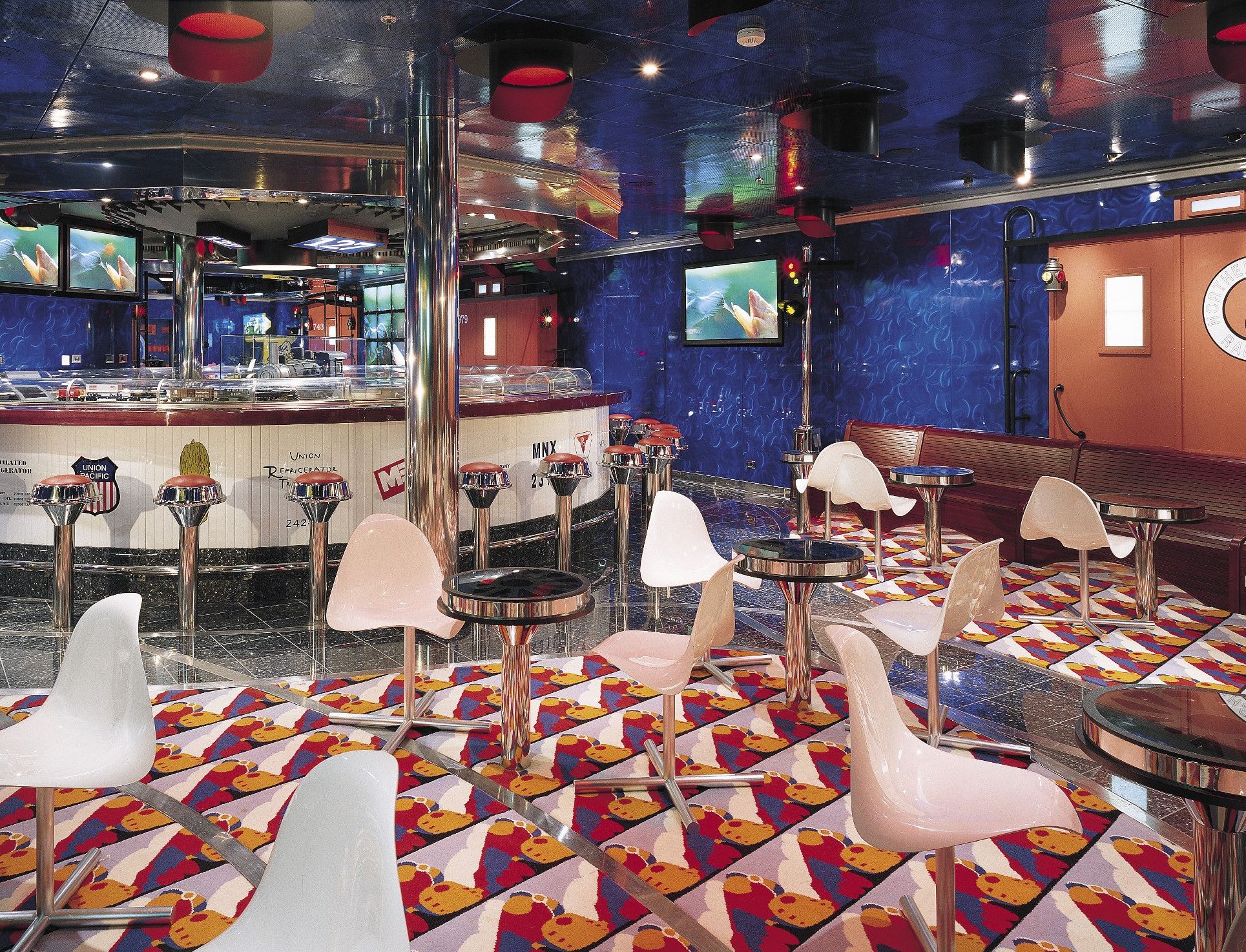 Carnival Valor retro-themed public lounge with counter seating and colourful patterned carpet