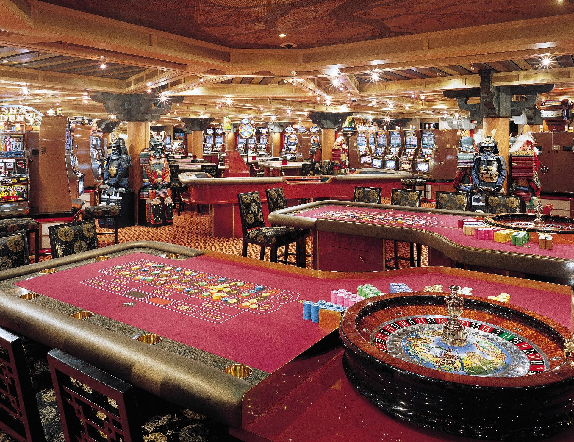 Carnival Valor casino with roulette and gaming tables and rows of slot machines