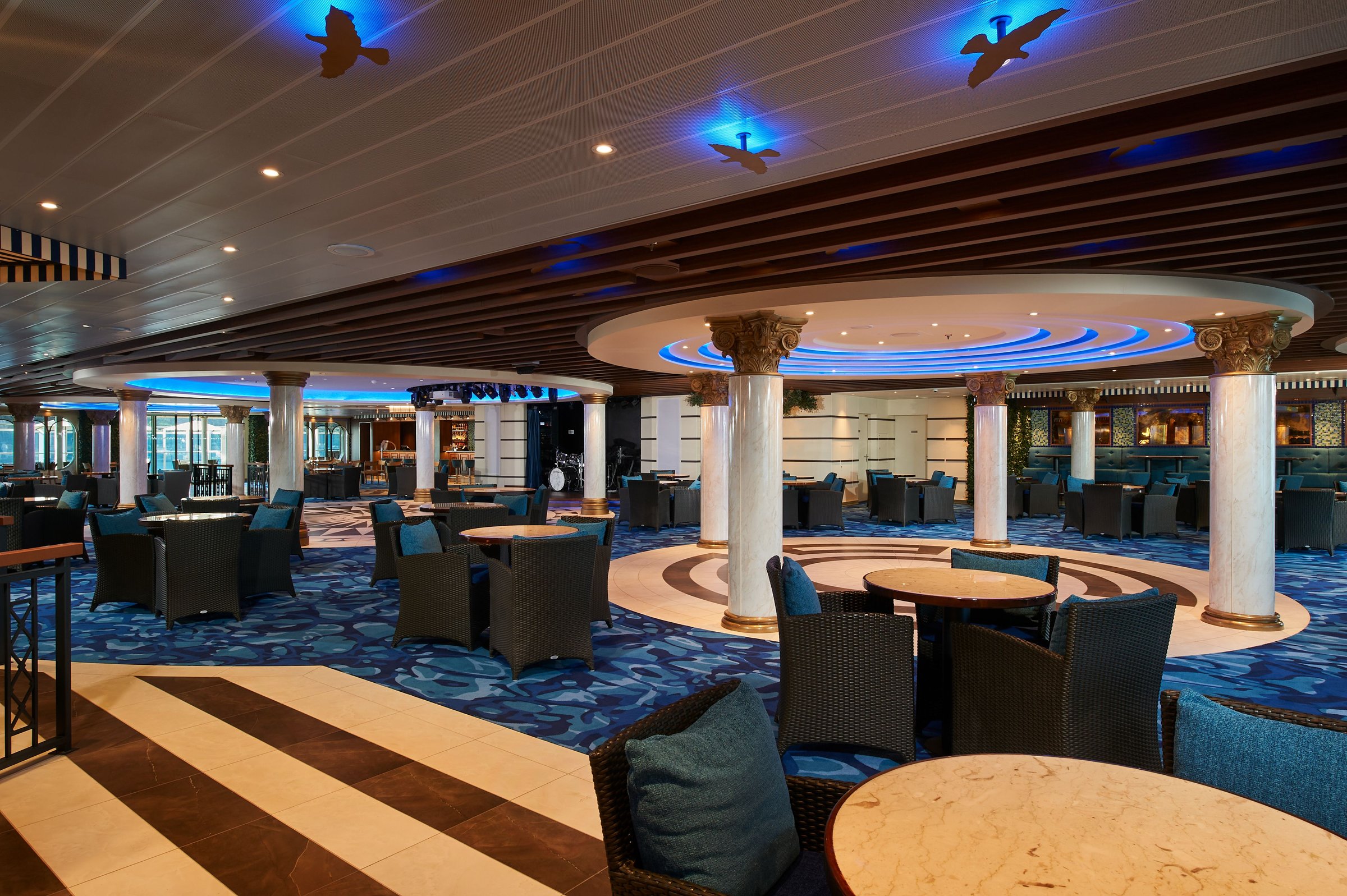 Carnival Venezia Gondola Lounge with columned seating areas and blue-lit ceiling details