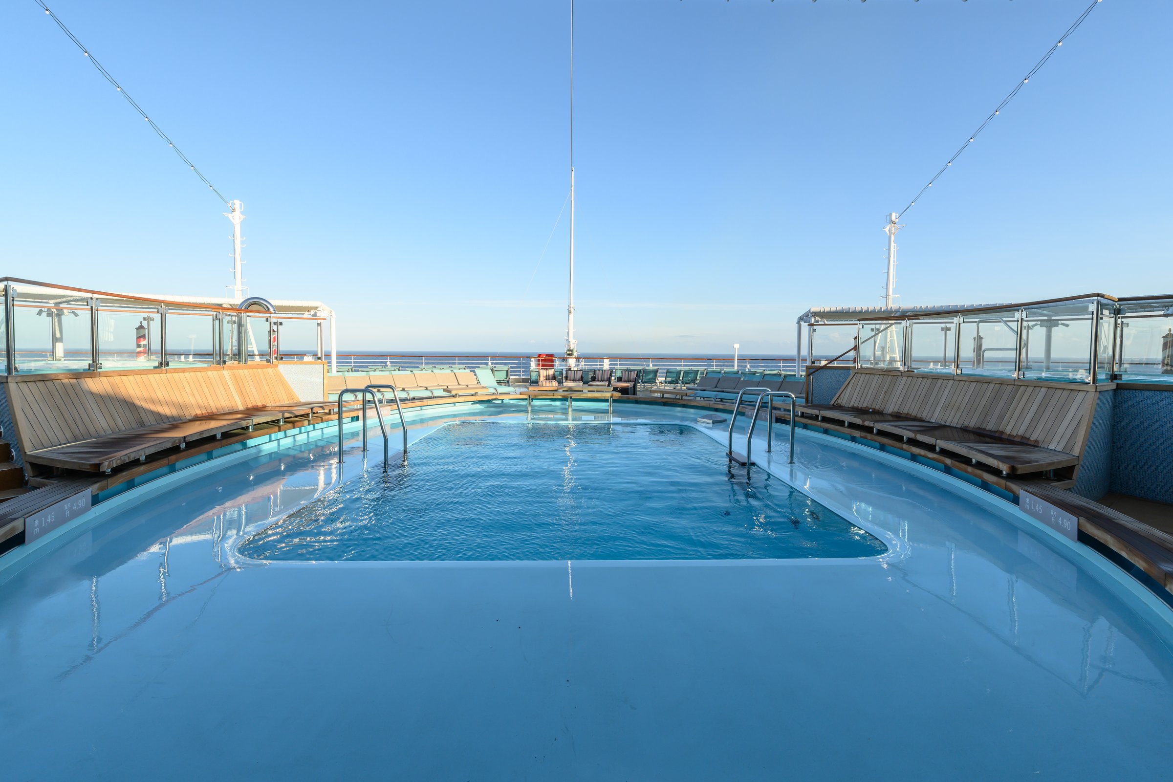 Carnival Venezia aft pool with curved lounge seating and open sea beyond the stern