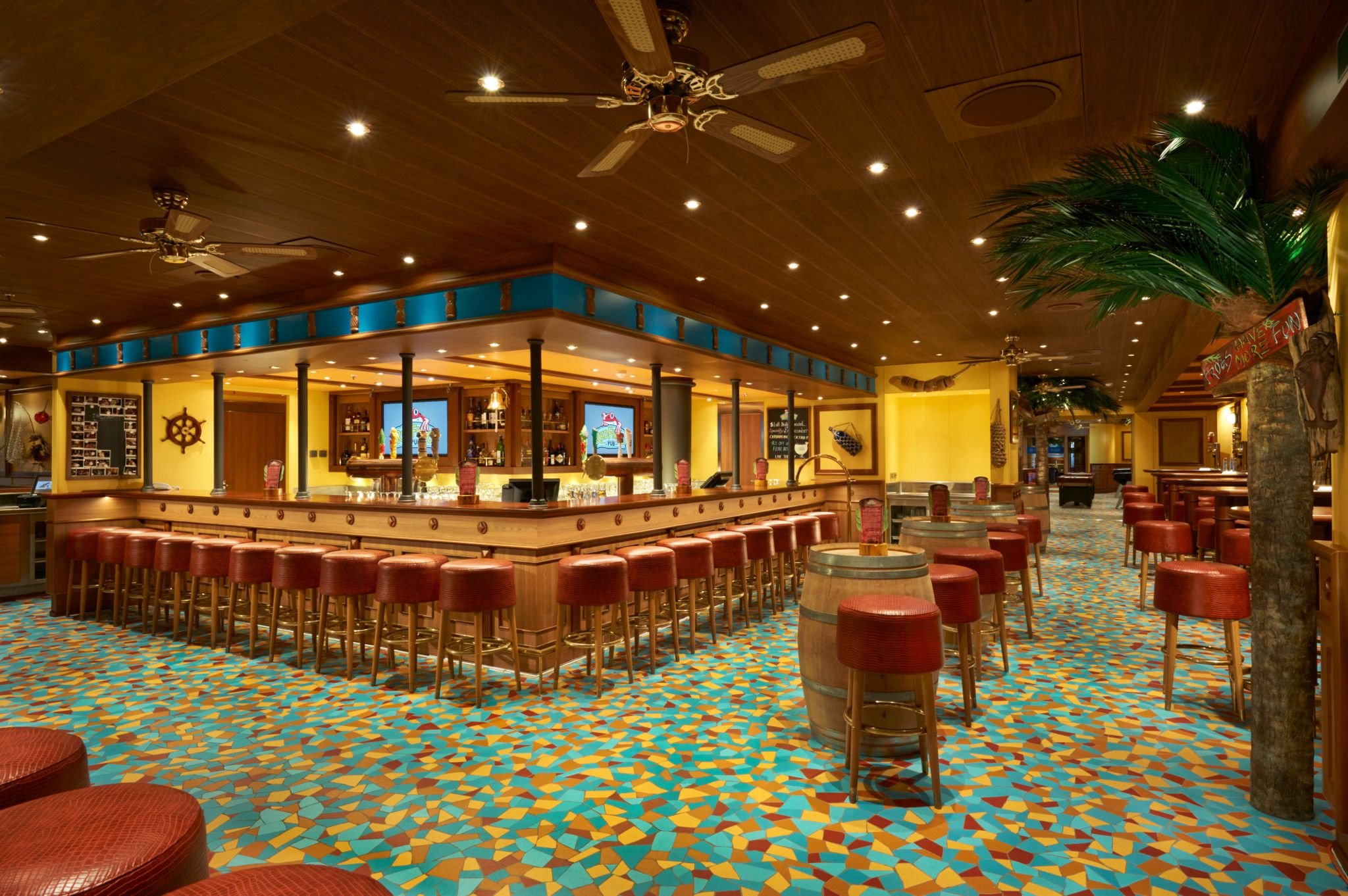 Carnival Vista Red Frog Pub bar with red stools, palm trees and colorful patterned carpet