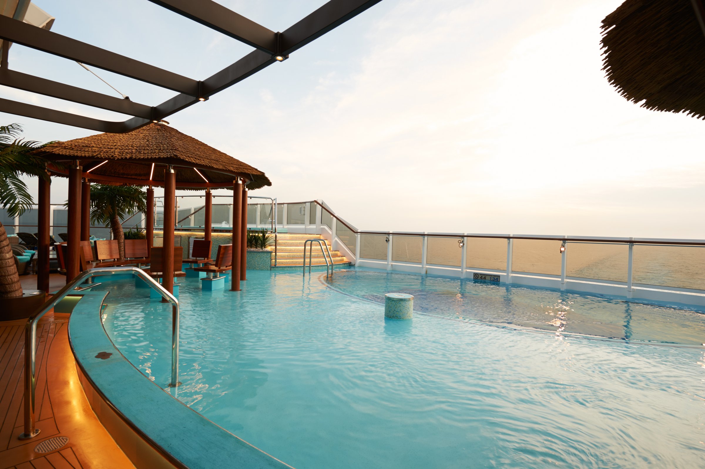 Carnival Vista Havana Pool with a thatched shade hut and glass railing over the sea