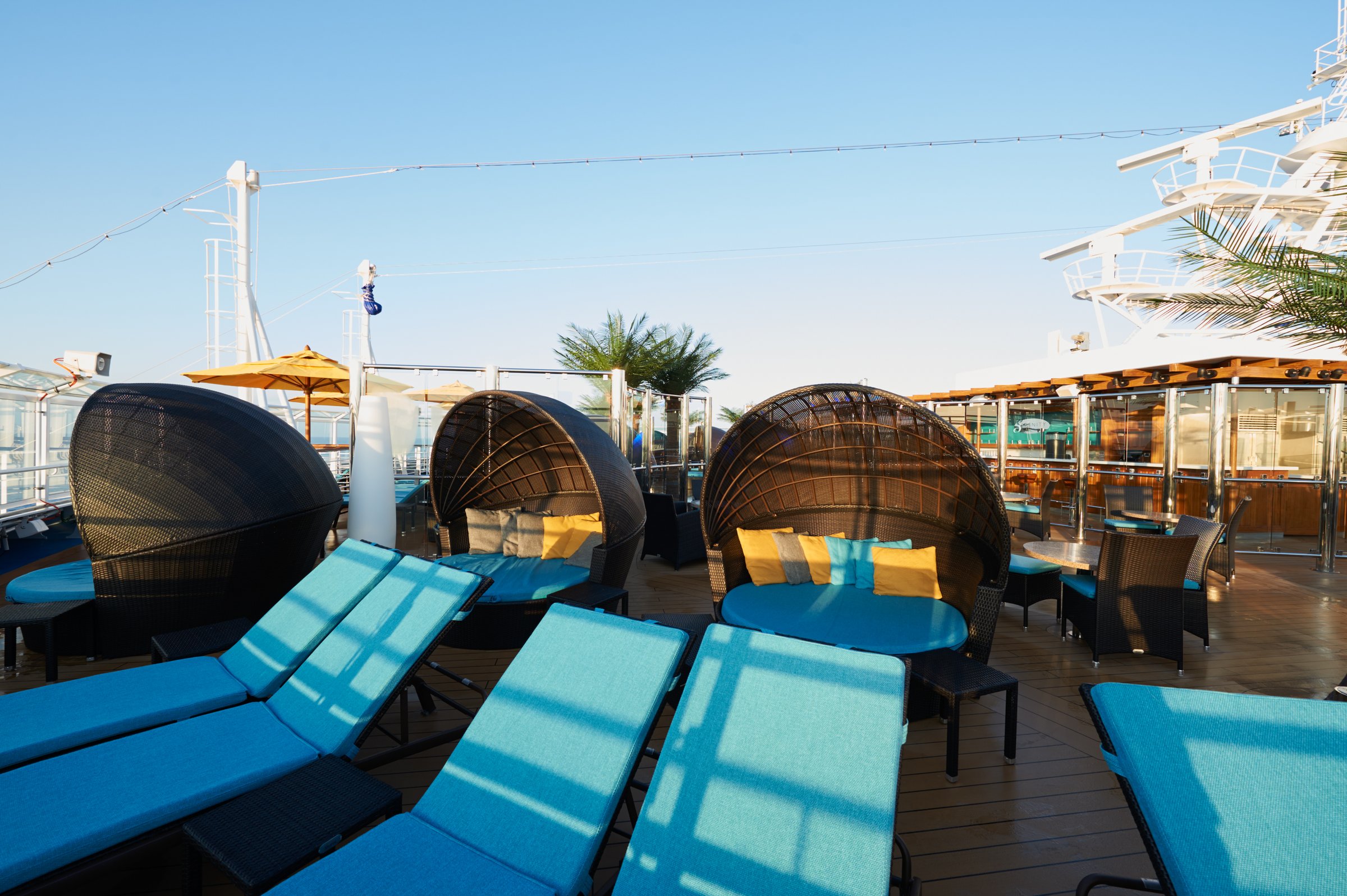 Carnival Vista Serenity adults-only retreat with wicker clamshell loungers and turquoise cushions