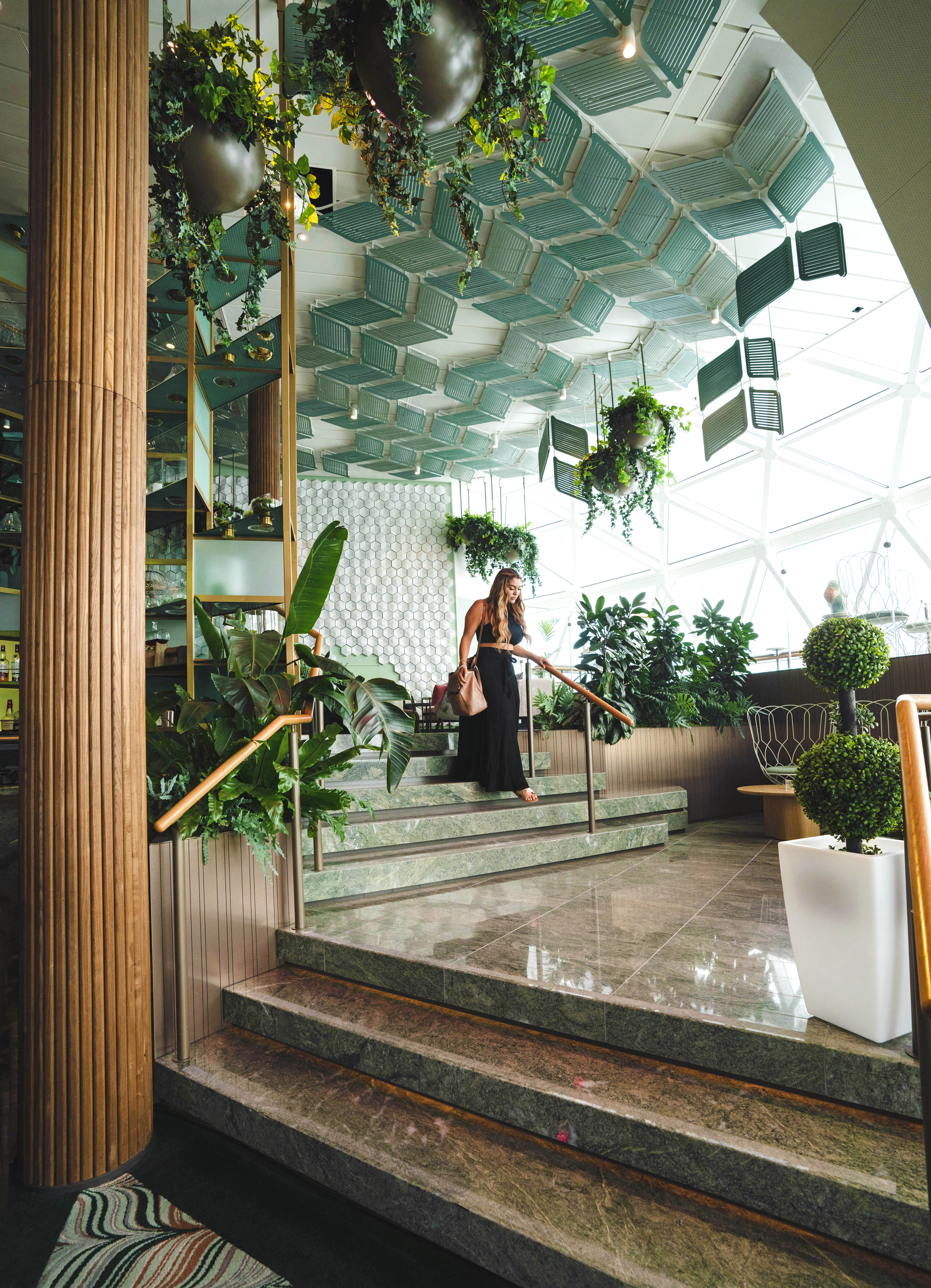 Celebrity Apex Eden lounge marble staircase with bright glass-roof daylight