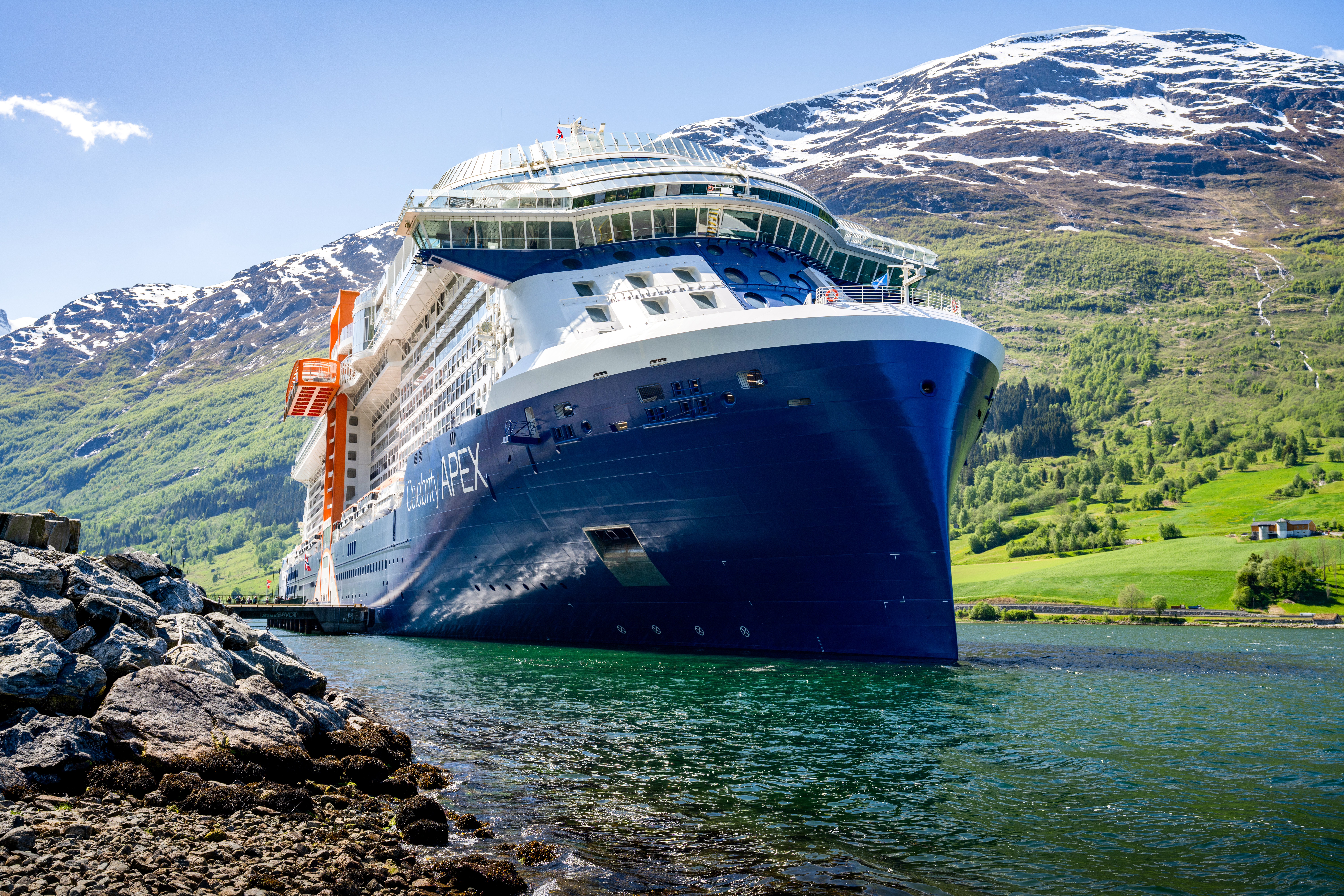 Celebrity Apex bow exterior in a sunny Norway fjord with APEX on the hull