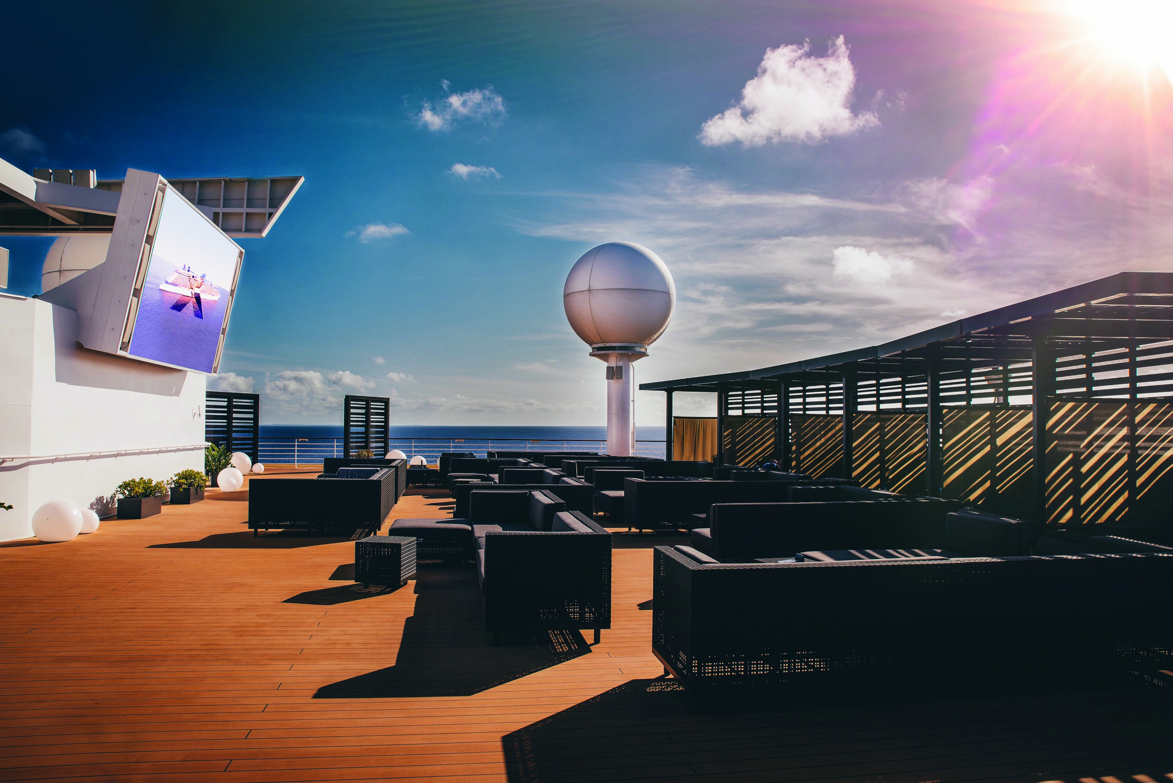Celebrity Infinity rooftop terrace lounge with outdoor screen in bright sun