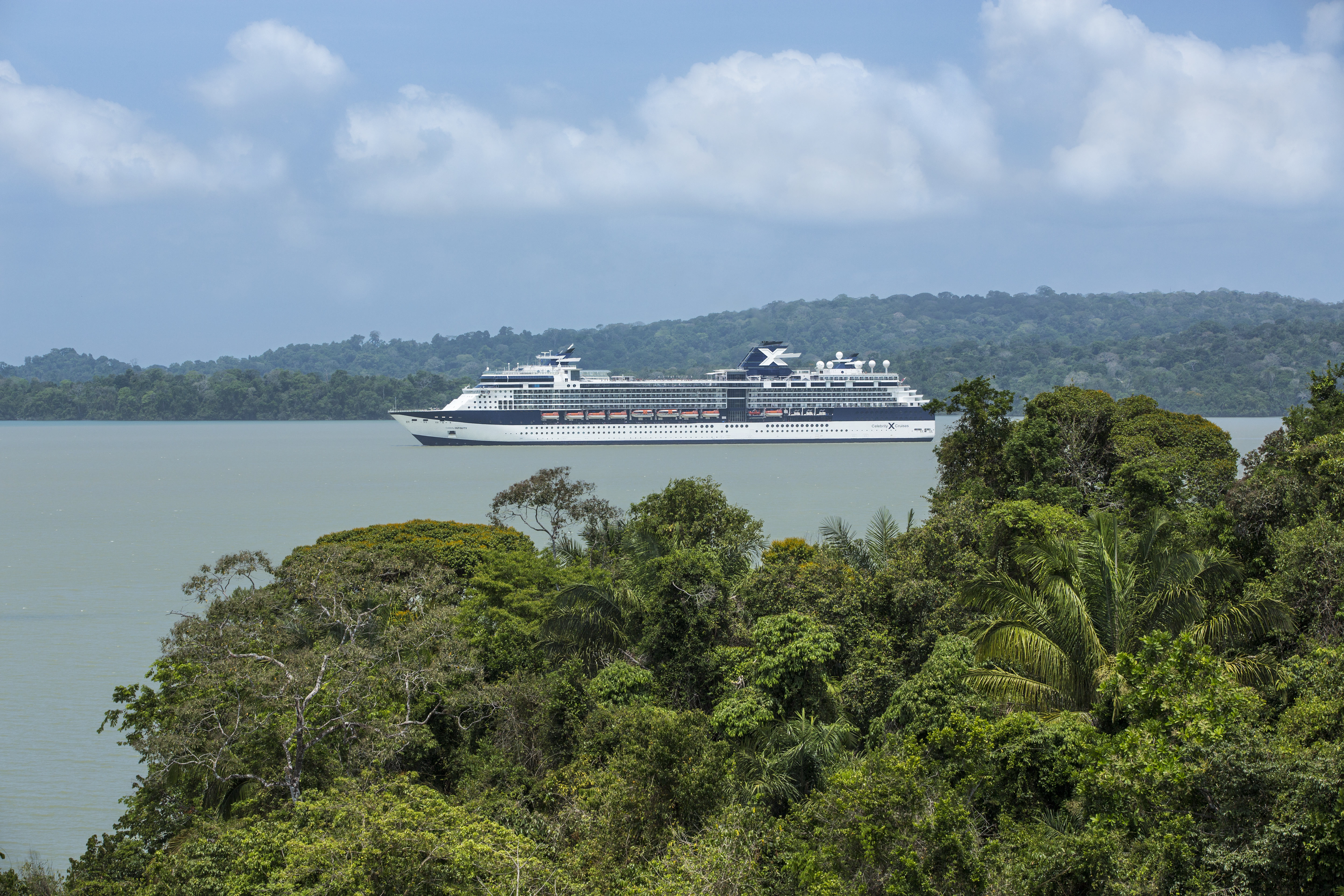 Celebrity Infinity sunny Panama Canal exterior with jungle banks