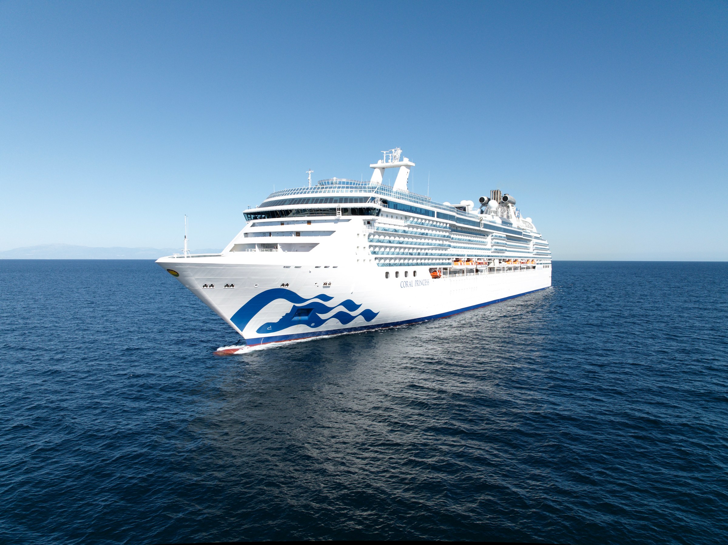 Coral Princess navigating the Panama Canal amid green hills and locks