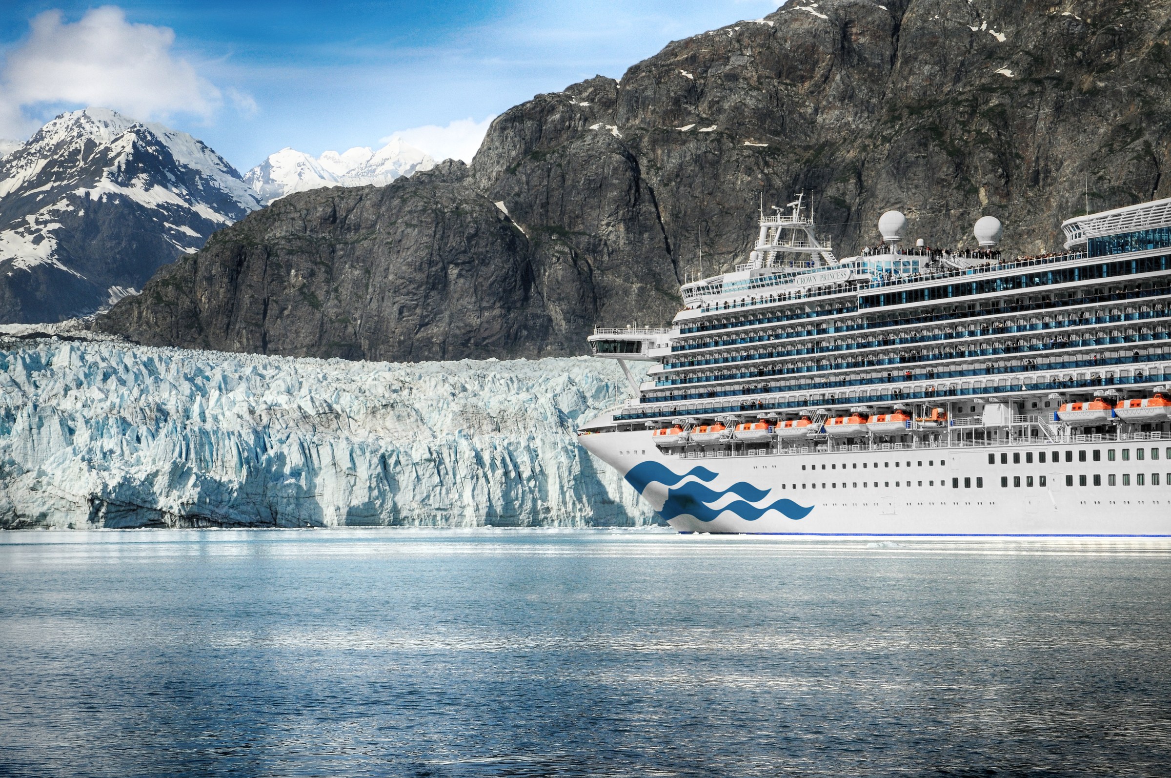 Crown Princess in front of a glacier in Glacier Bay, Alaska, under blue skies