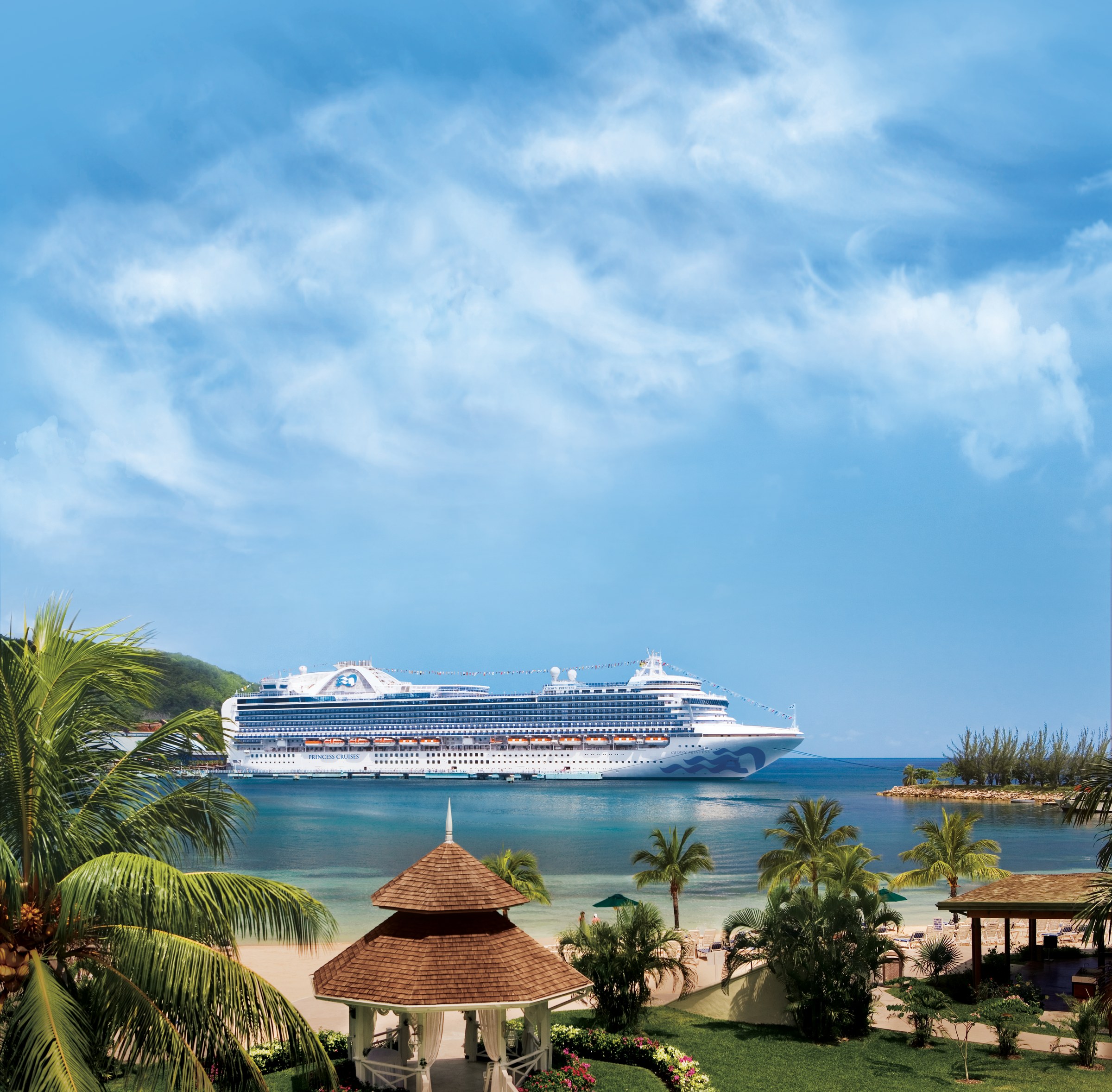 Crown Princess at sea beyond a palm-lined beach in Ocho Rios, Jamaica