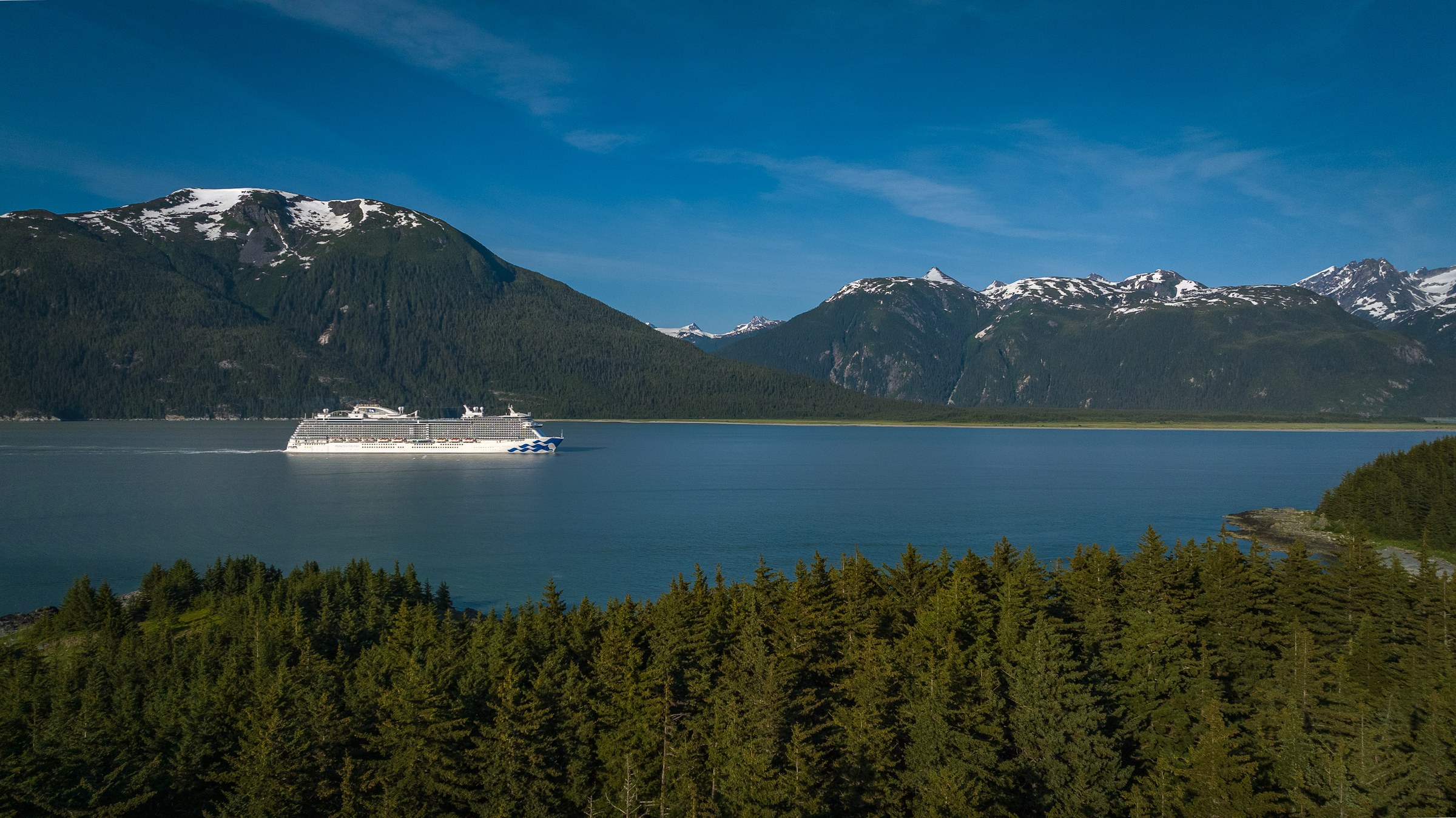 Discovery Princess sailing Haines, Alaska, with snowy peaks behind