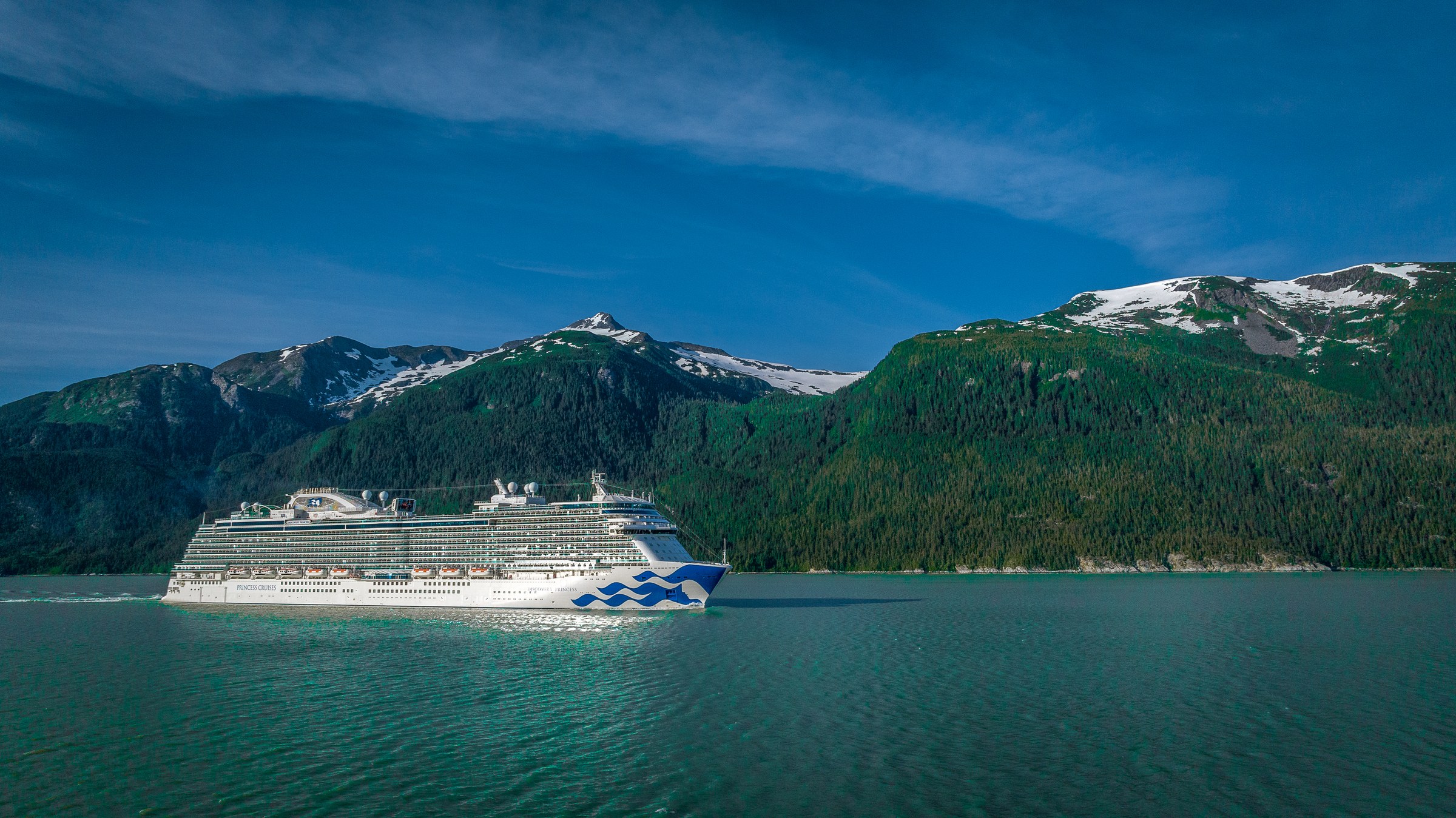 Discovery Princess sailing Haines, Alaska, with snowy peaks behind
