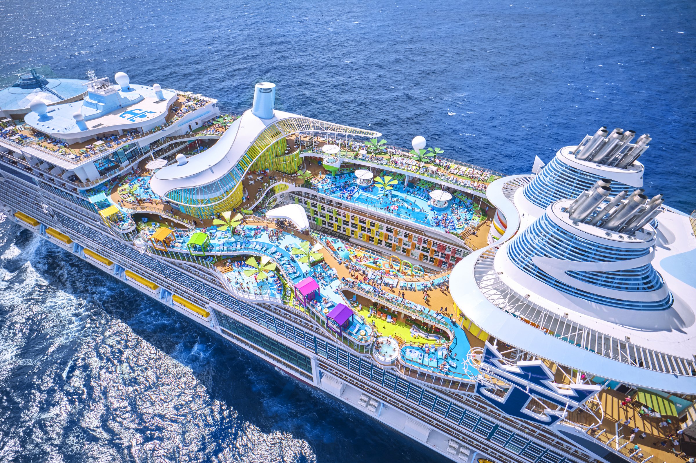 Chill Island pool decks aboard Icon of the Seas in bright sunshine, seen from above