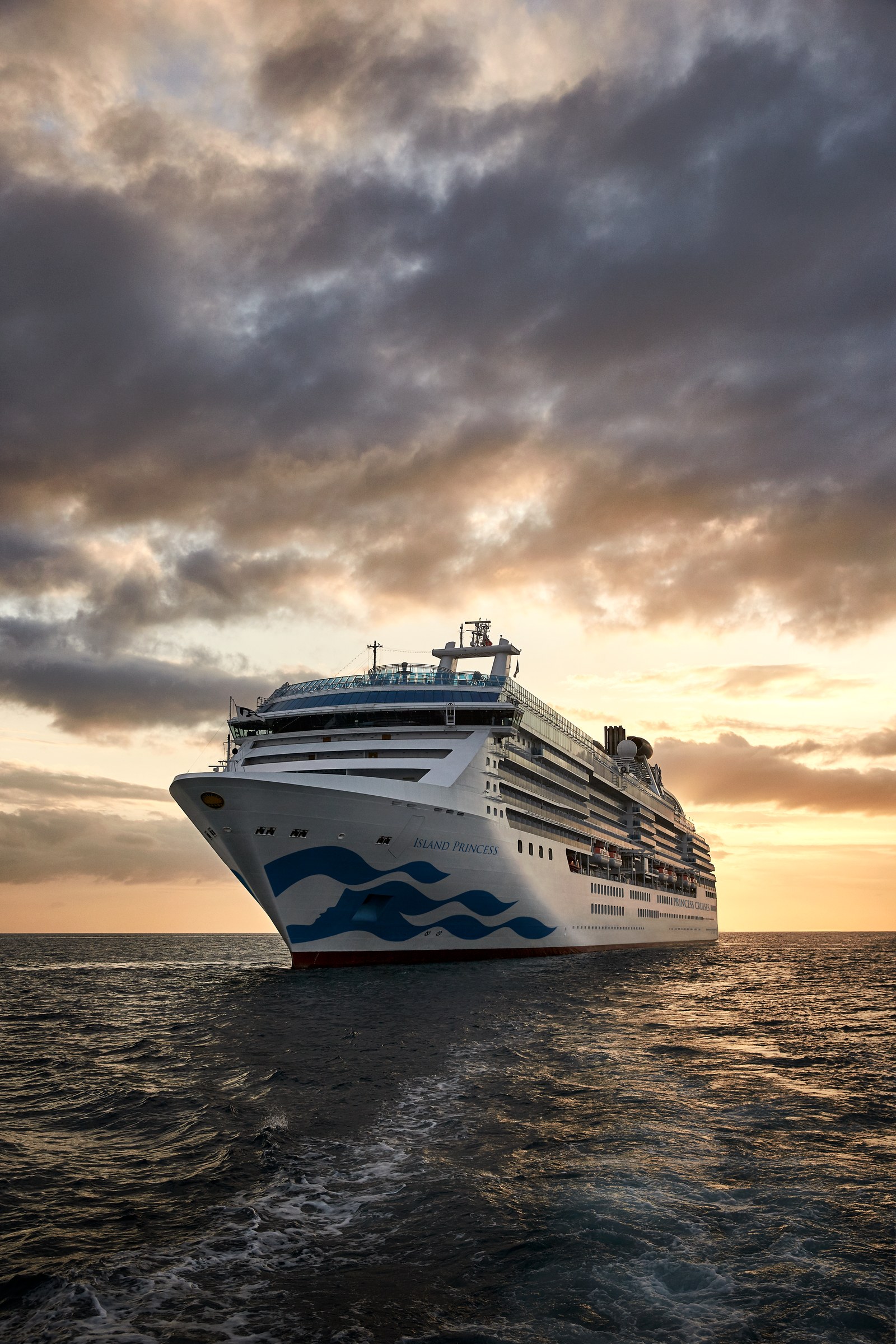 Island Princess sailing away at sunset under dramatic clouds