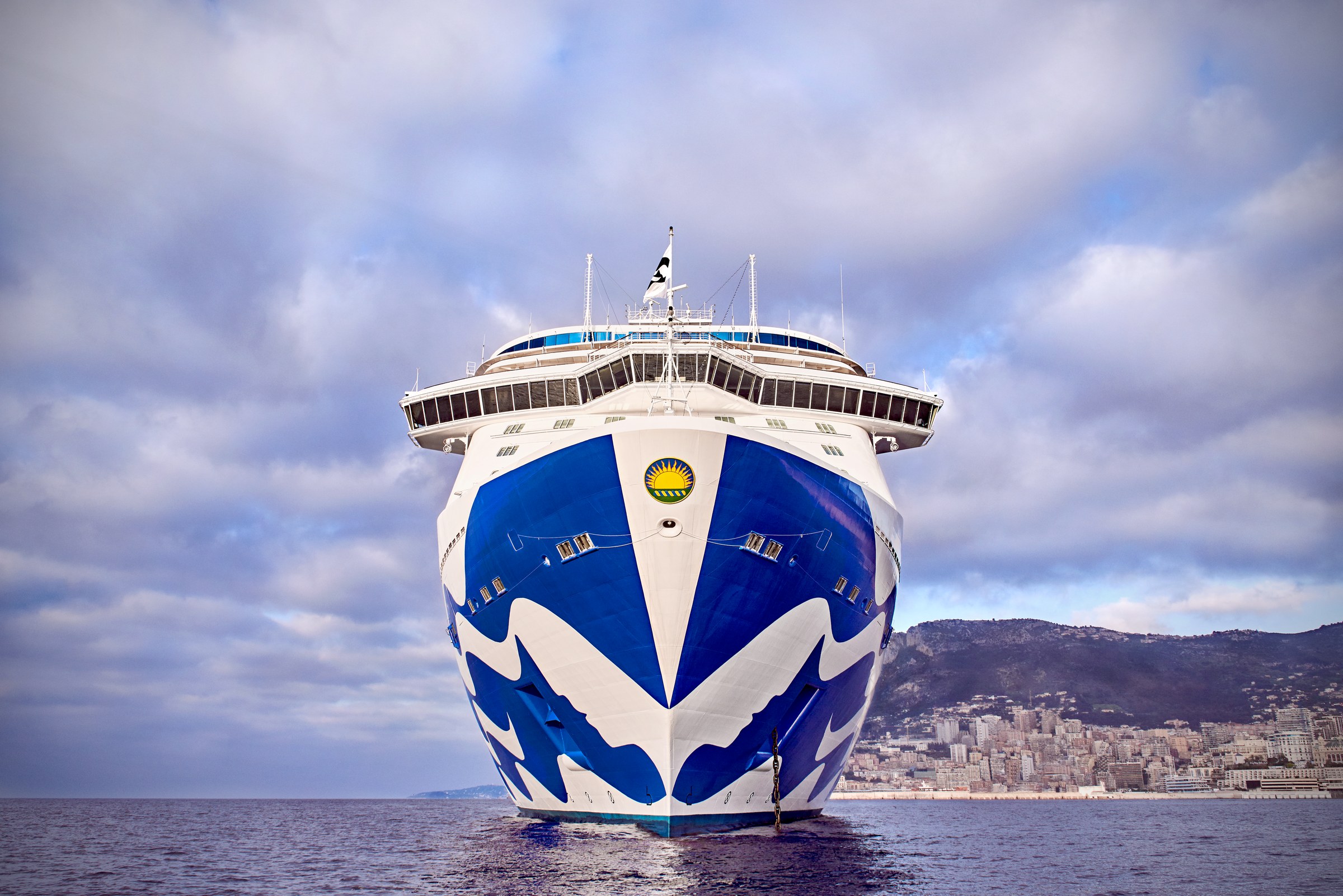 Majestic Princess bow-on at Monte Carlo with the city and mountain behind