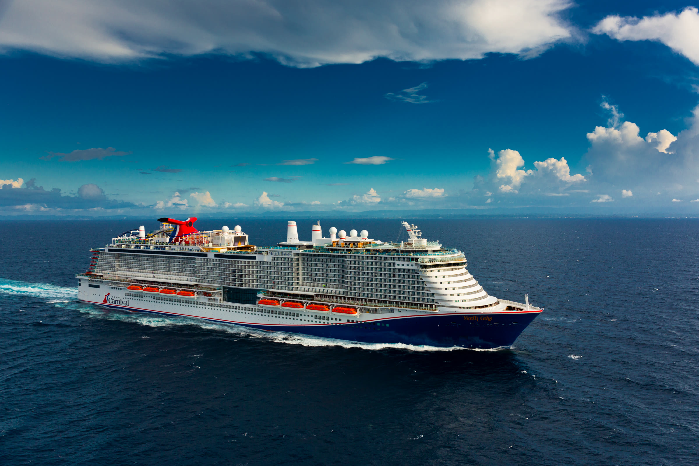 Mardi Gras sailing open ocean under sunny skies, aerial starboard view