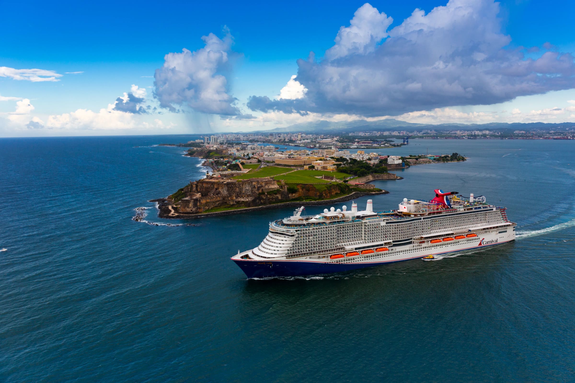 Mardi Gras sunny aerial sailing past Old San Juan fort