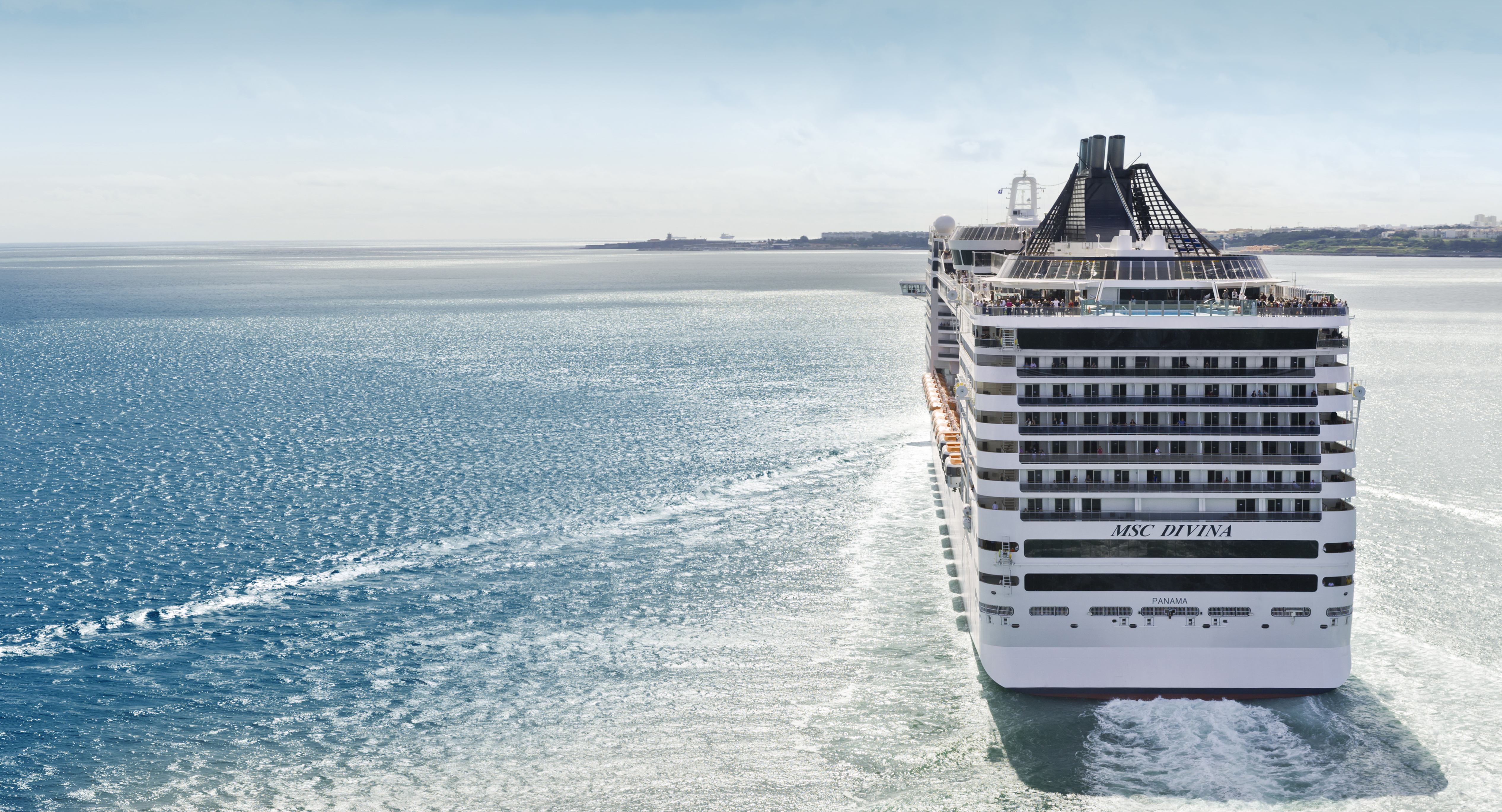 MSC Divina stern aerial underway under a clear sky with DIVINA on the hull