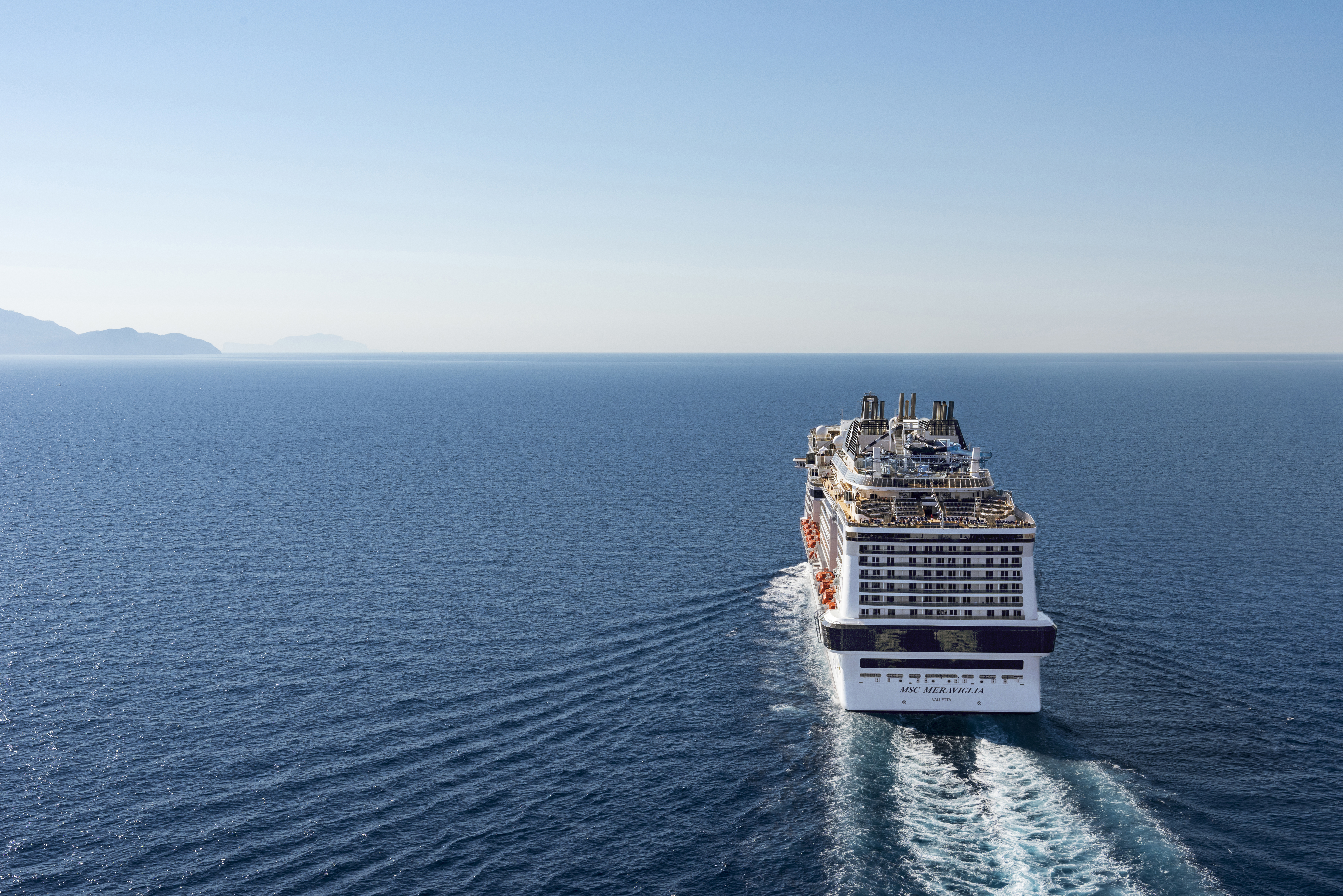 MSC Meraviglia aft aerial underway under a clear sky