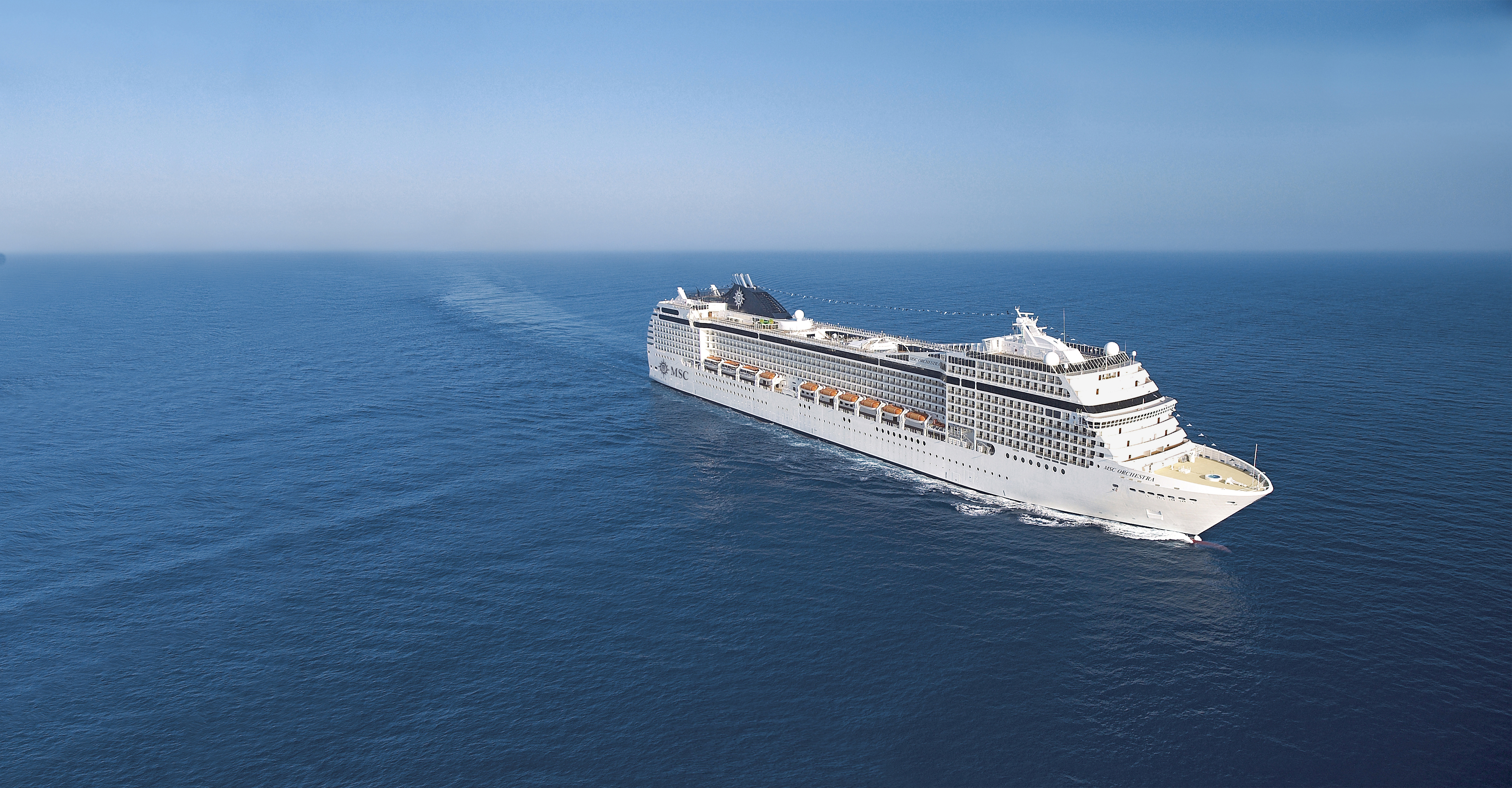 MSC Orchestra sailing at sea under clear midday sky