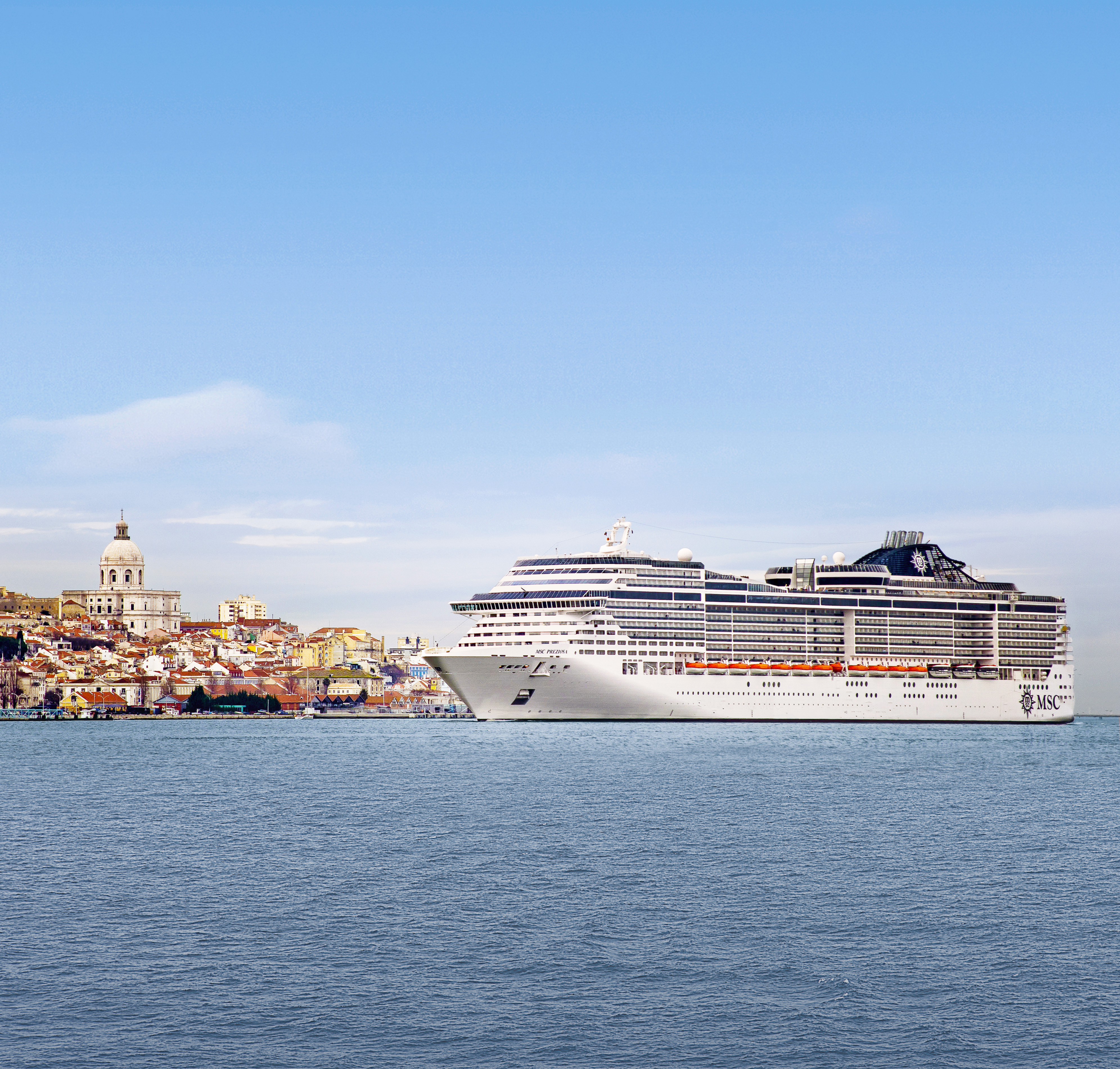 MSC Preziosa sunny exterior profile at sea with Lisbon hillside behind
