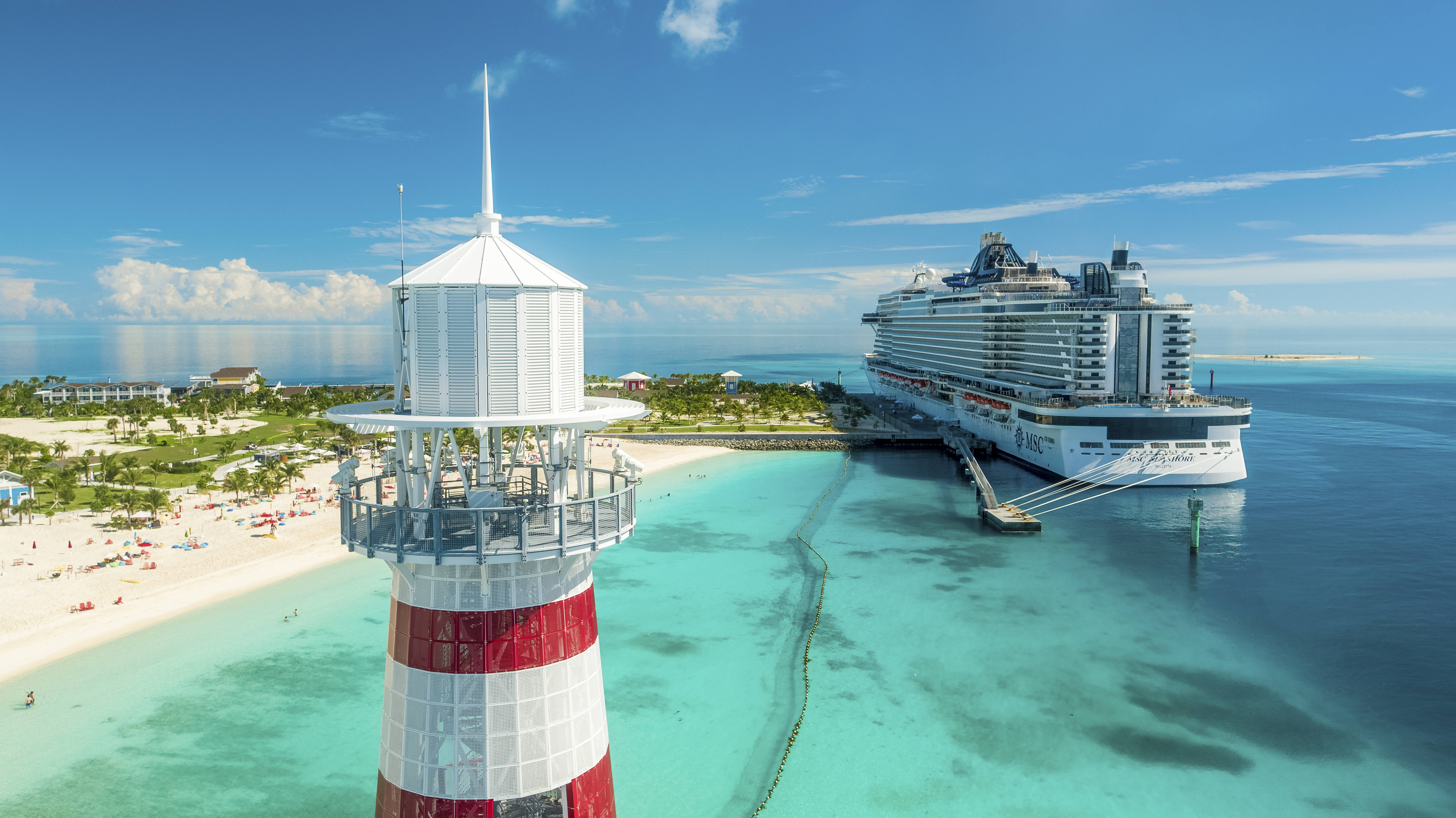 MSC Seashore stern aerial at Ocean Cay pier with striped lighthouse