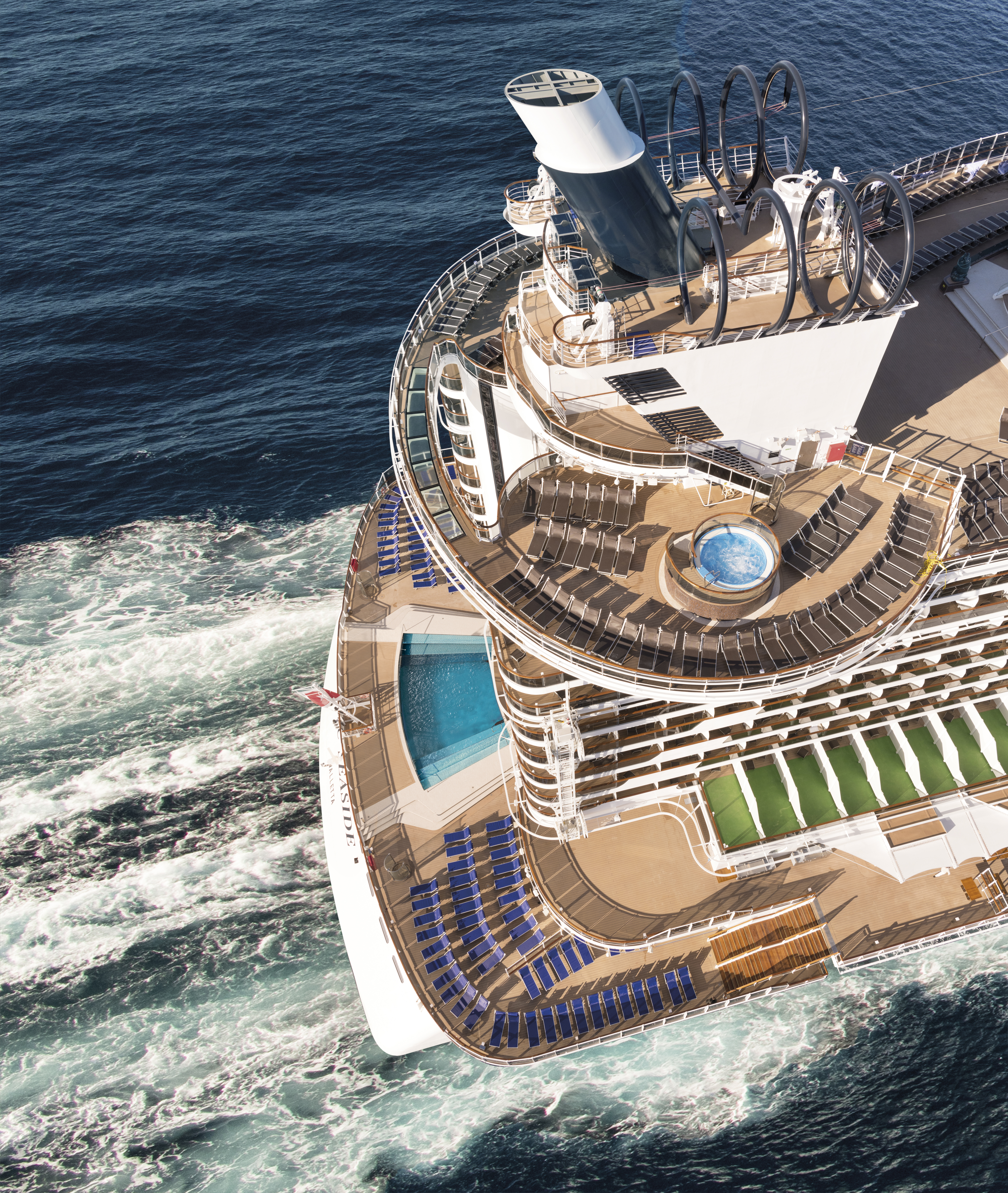 MSC Seaside aft aerial underway with white wake under midday sun