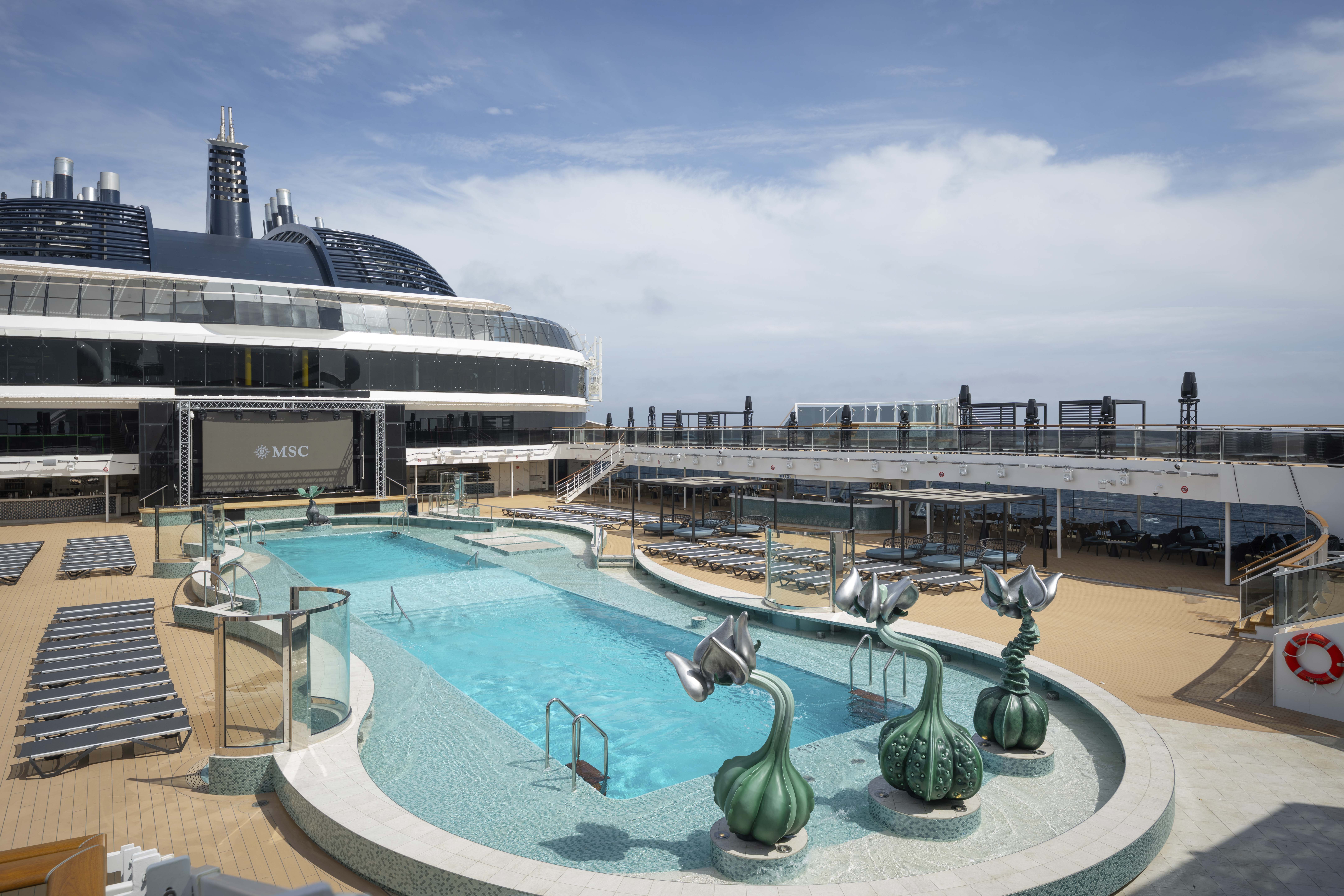MSC World America outdoor pool with LED stage and plant fountains on a sunny day