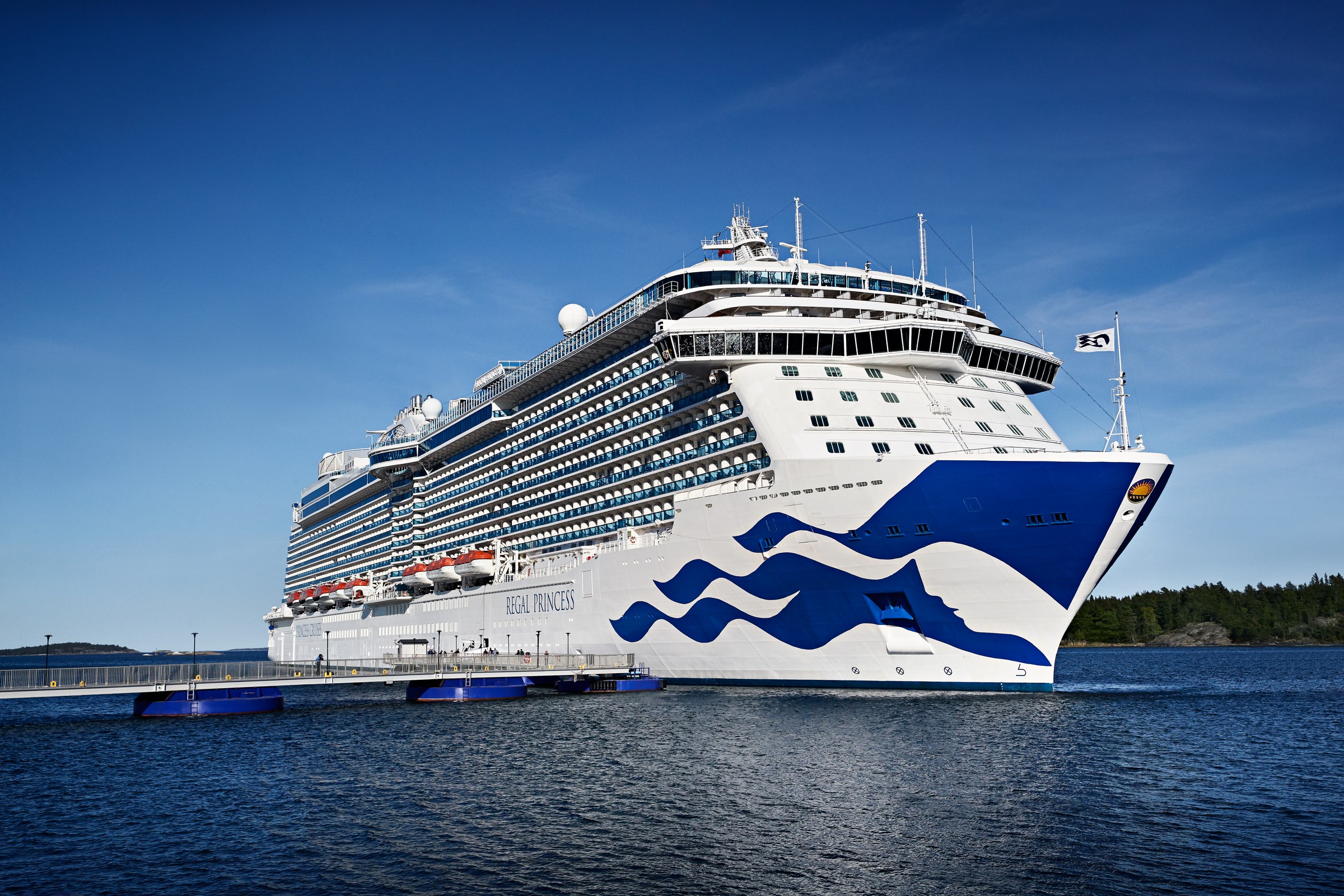 Regal Princess at Stockholm on a sunny day, ship name visible on the hull