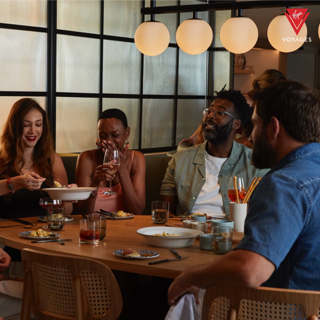 Bright modern Extra Virgin dining scene with friends sharing plates and drinks