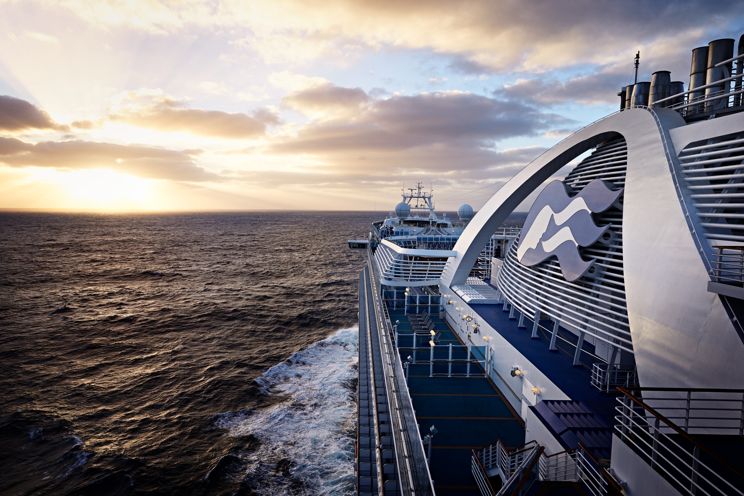 Ruby Princess upper decks and funnel at sunset over the sea