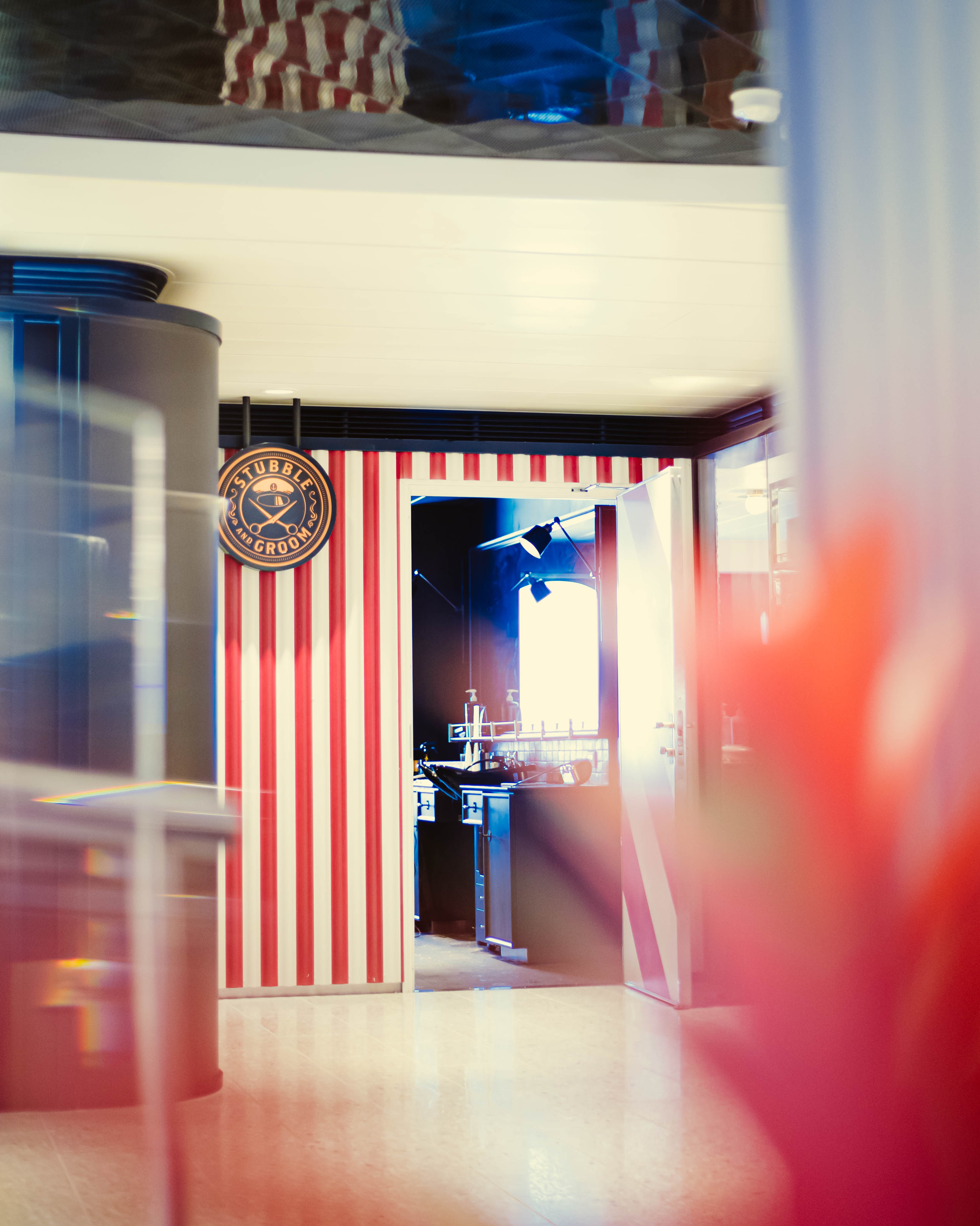 Stubble & Groom barber-shop entrance with red-and-white striped doorway.