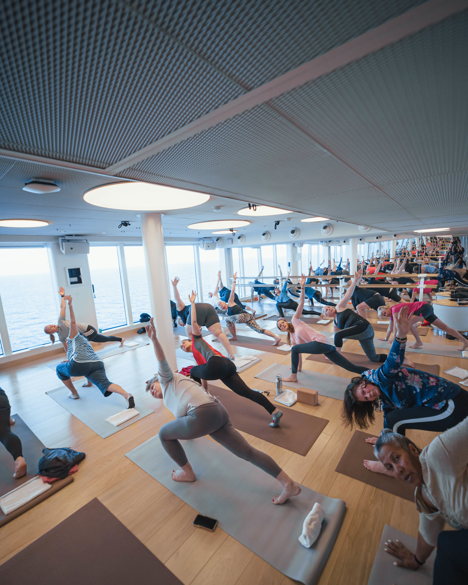 Full group fitness yoga class in the bright B-Complex studio.