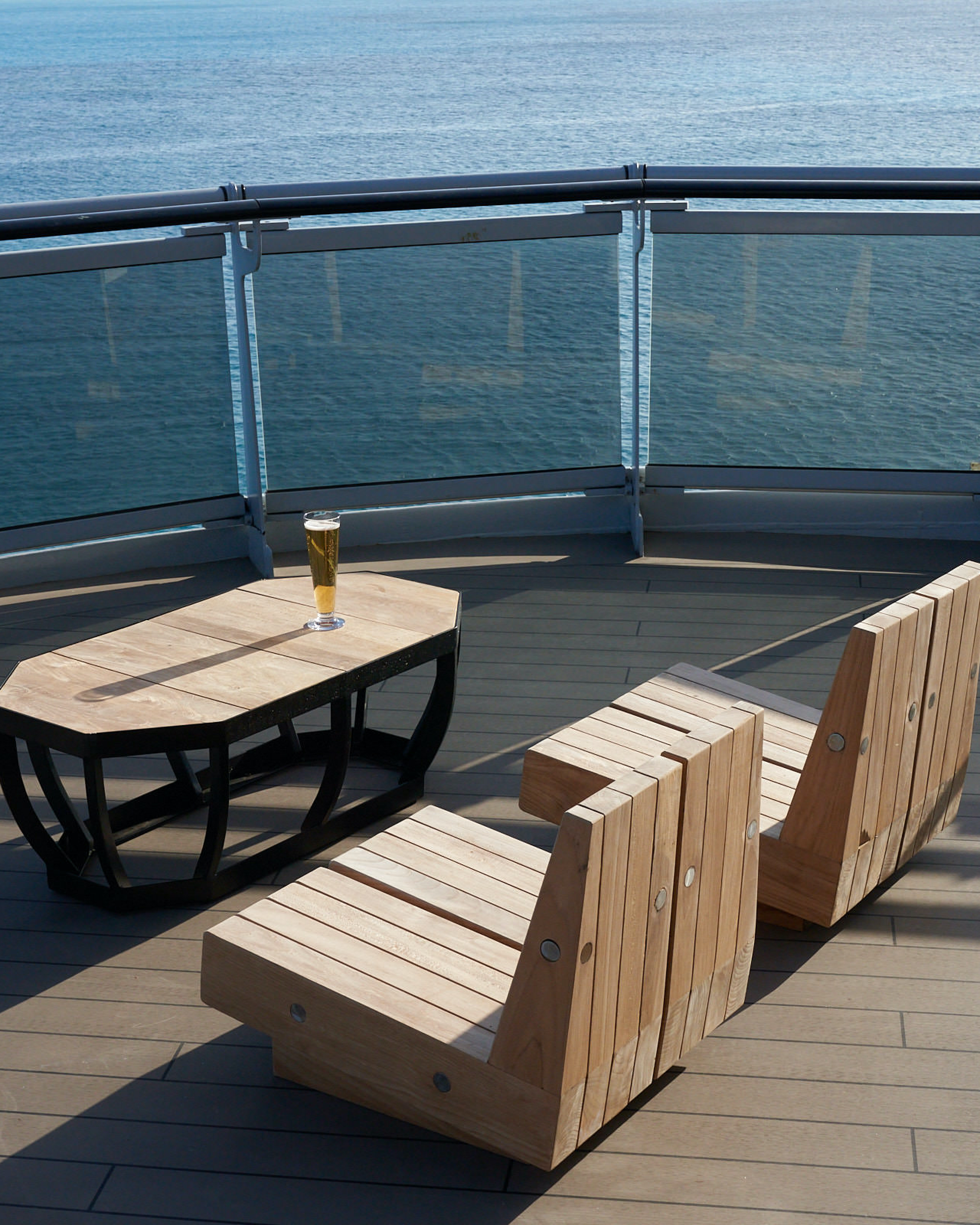 Sunny Dock seating with ocean view and a beer on the table.