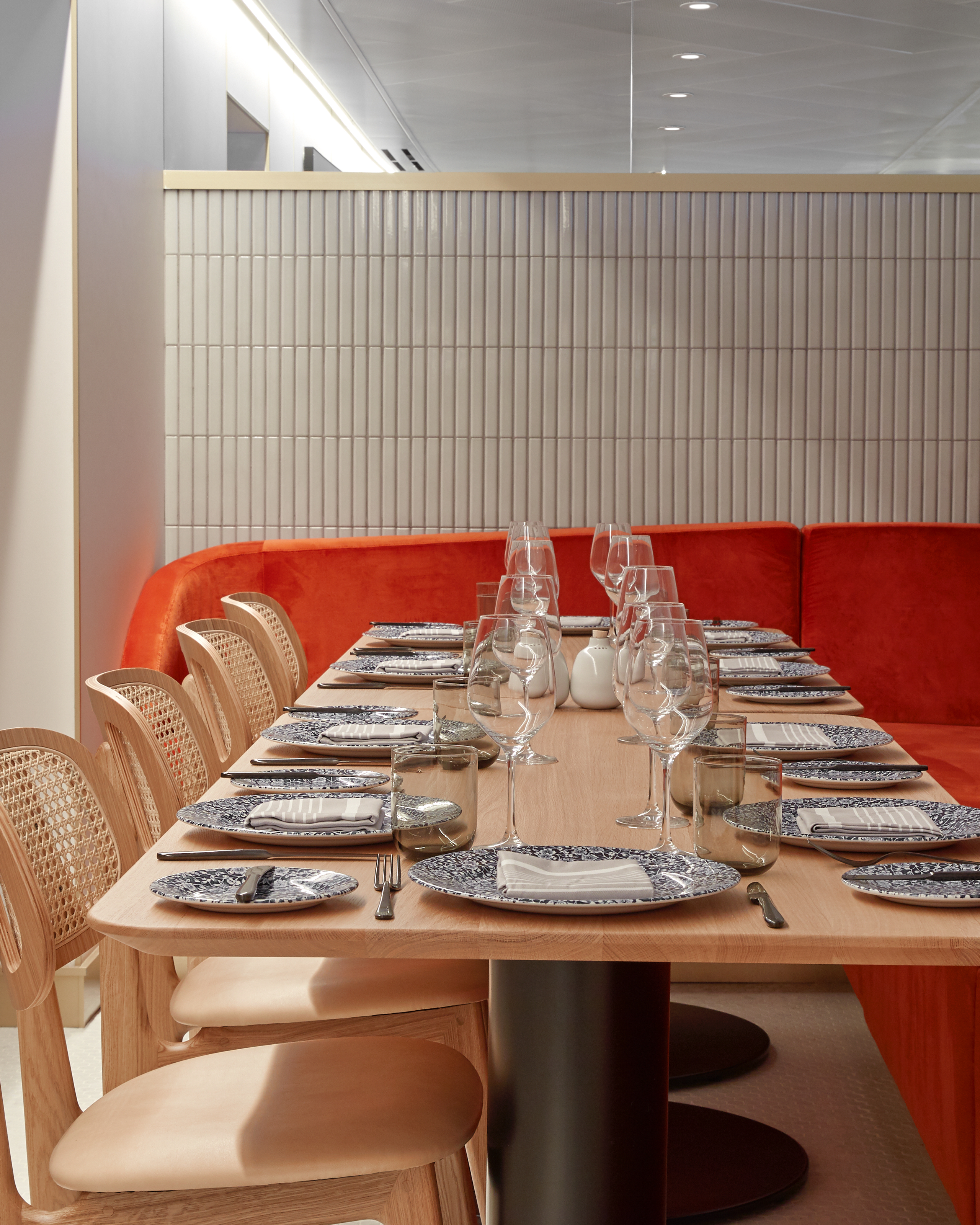 Extra Virgin interior dining table with orange banquette.