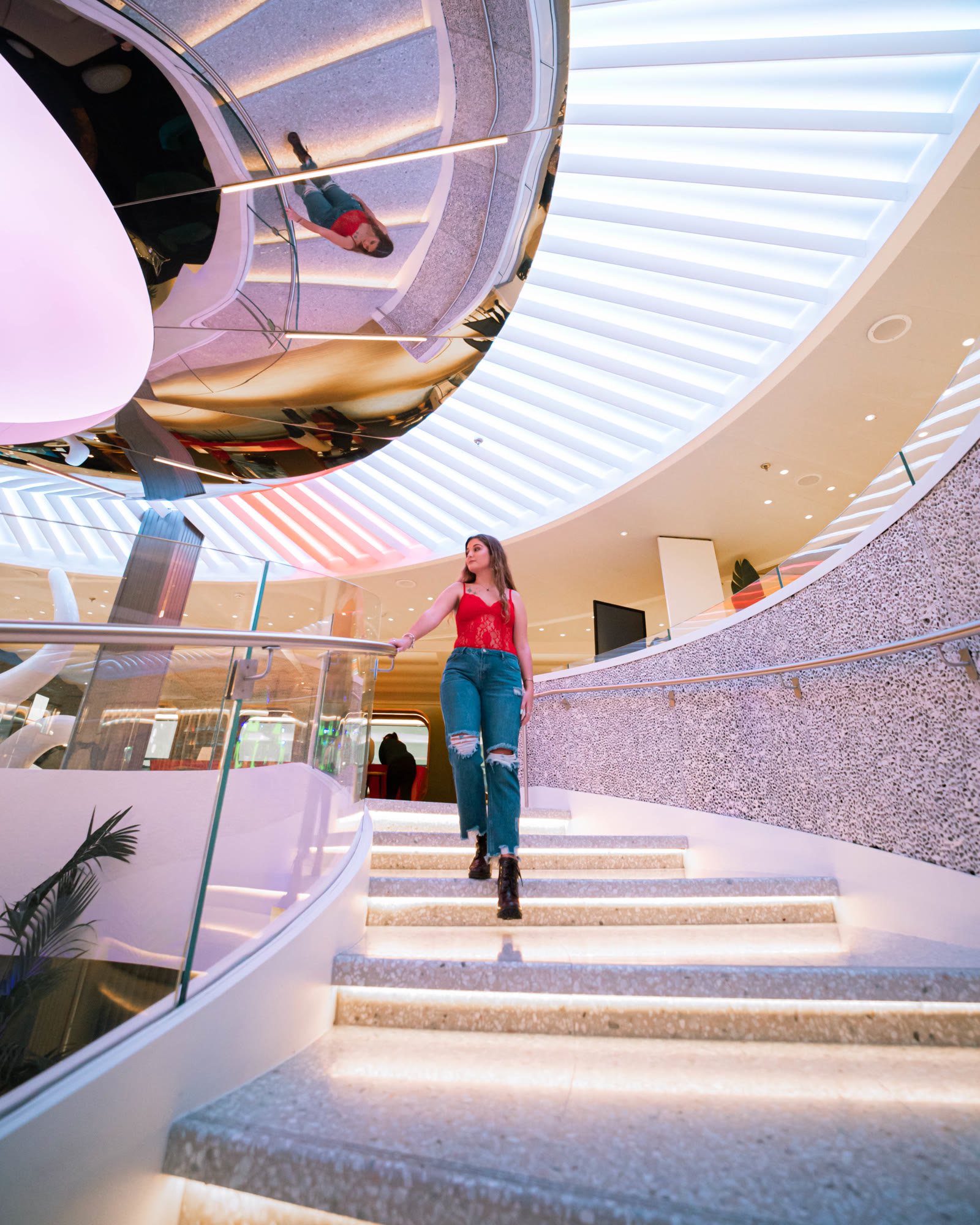 person on sculptural stairs; strong modern-architecture composition.