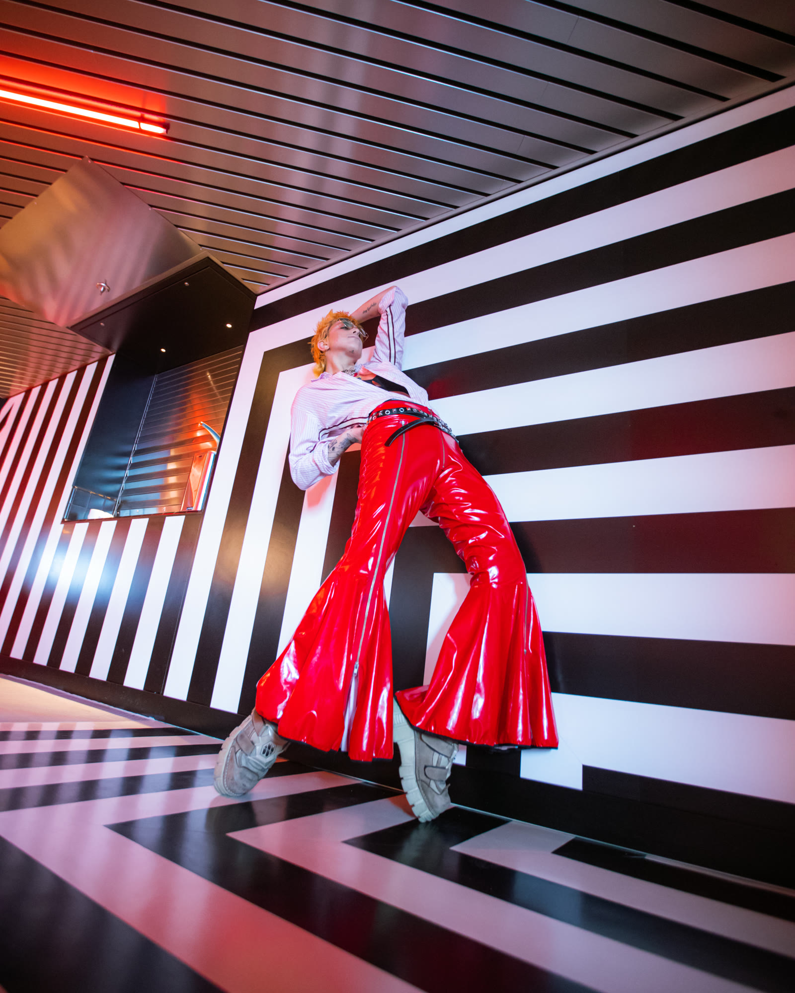 vivid red fashion portrait against graphic black/white interior.