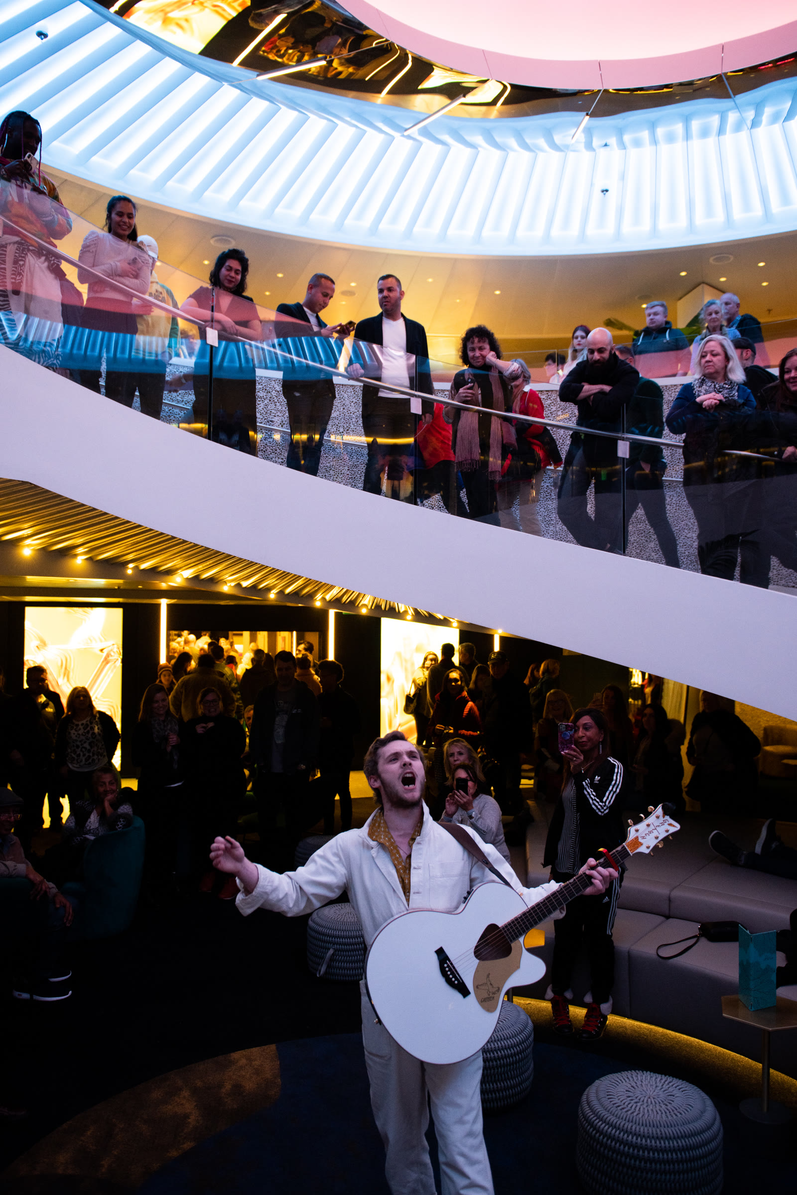 live performance in the bright, open atrium; energetic onboard hero.