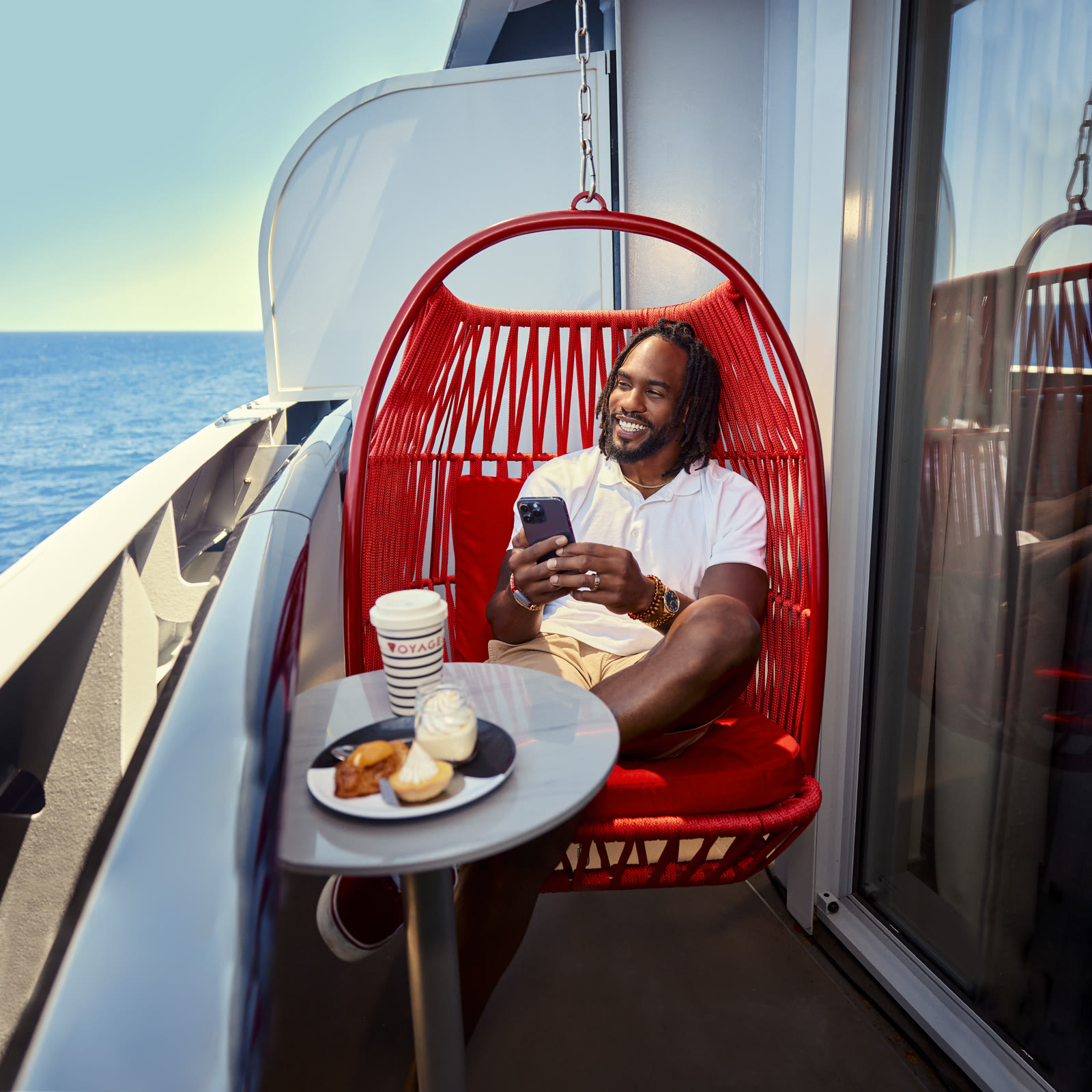 Sunny sea-terrace lifestyle: sailor in red egg chair enjoying Ship Eats